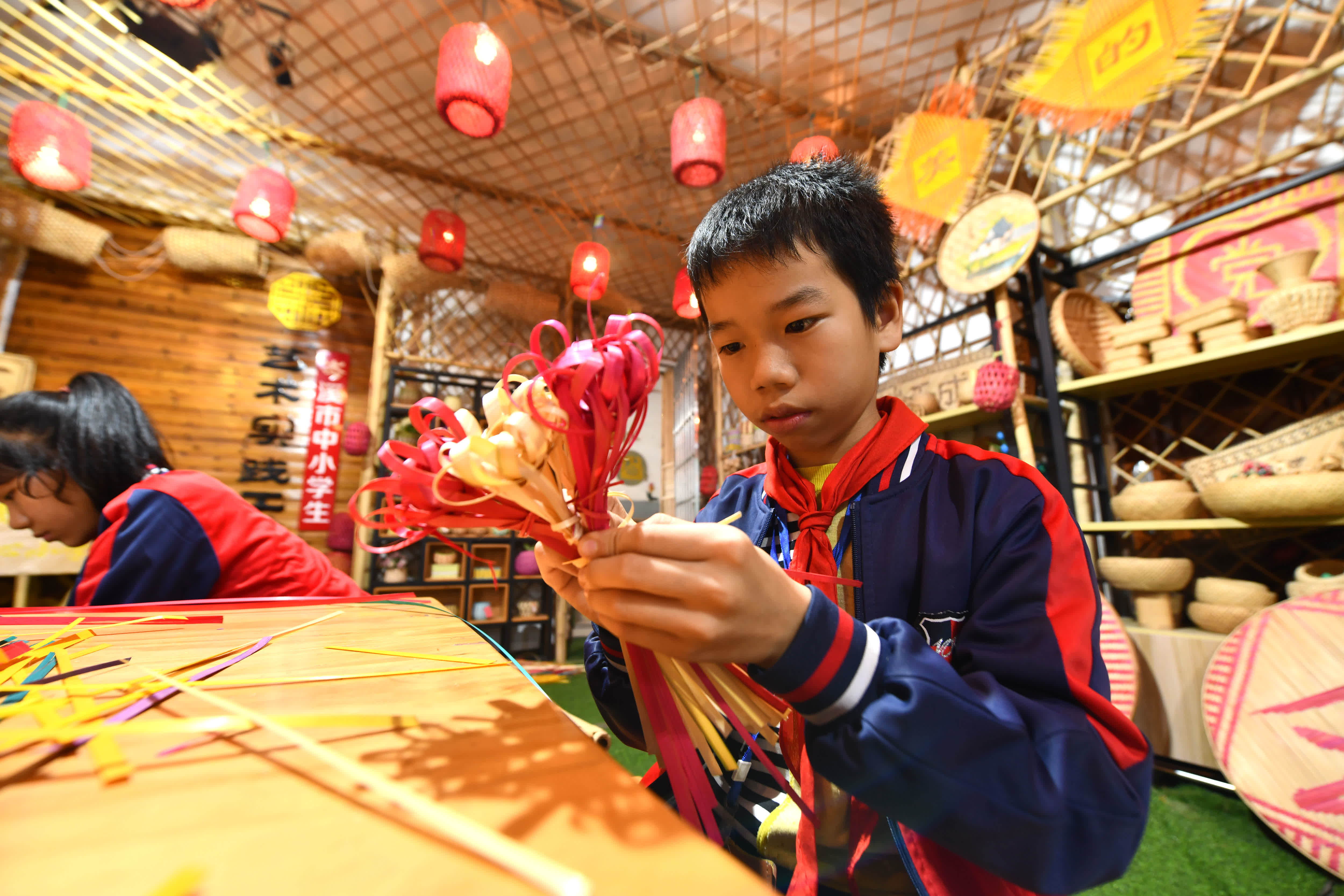  11月28日，在廣西岑溪市南渡中心小學，小學生在練習竹芒編織技藝。（新華社）