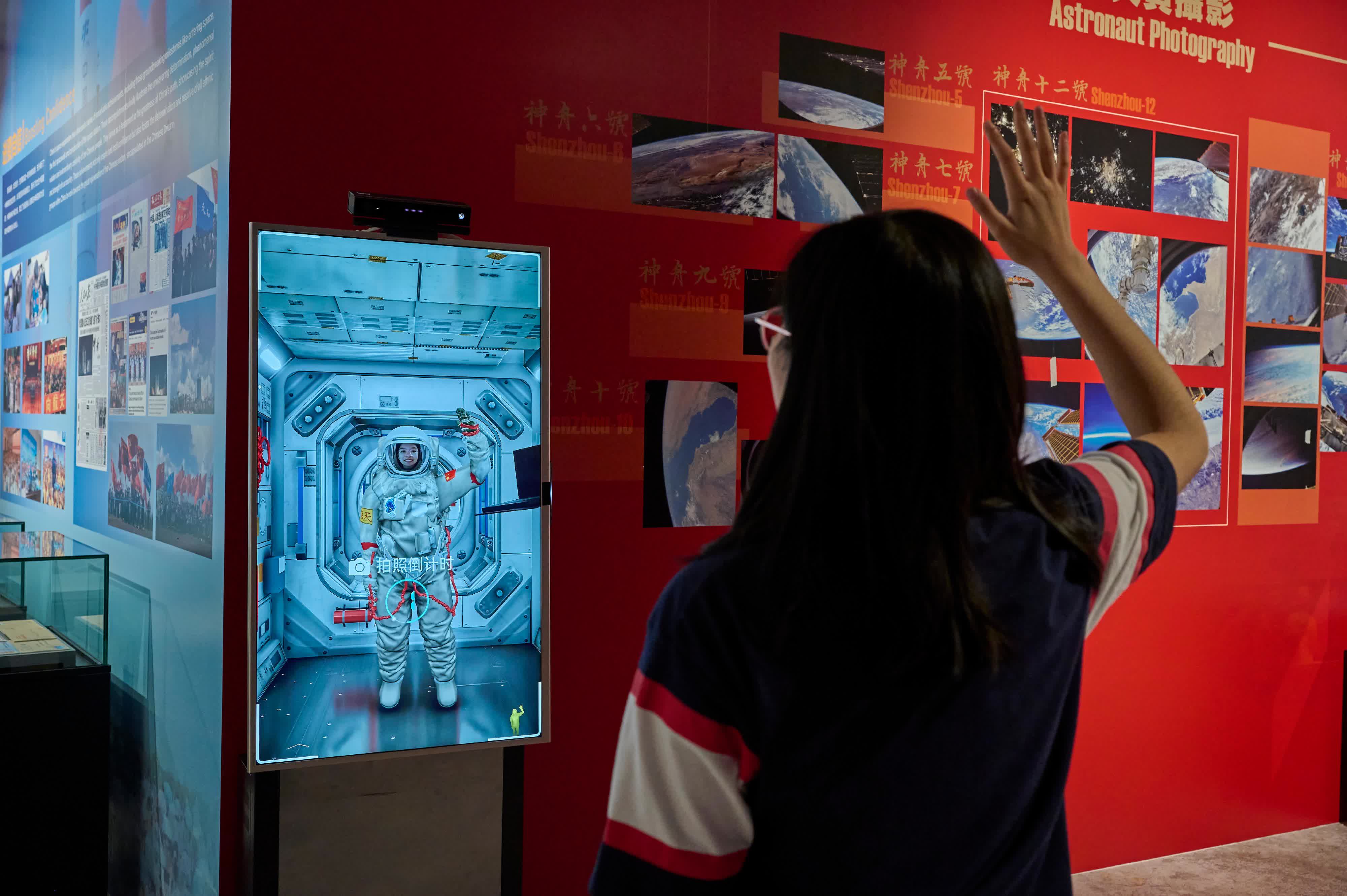 圖示觀眾在「太空照相館」穿上虛擬航天服,在空間站艙內和艙外拍攝相片留念。 圖示觀眾在「太空照相館」穿上虛擬航天服,在空間站艙內和艙外拍攝相片留念。