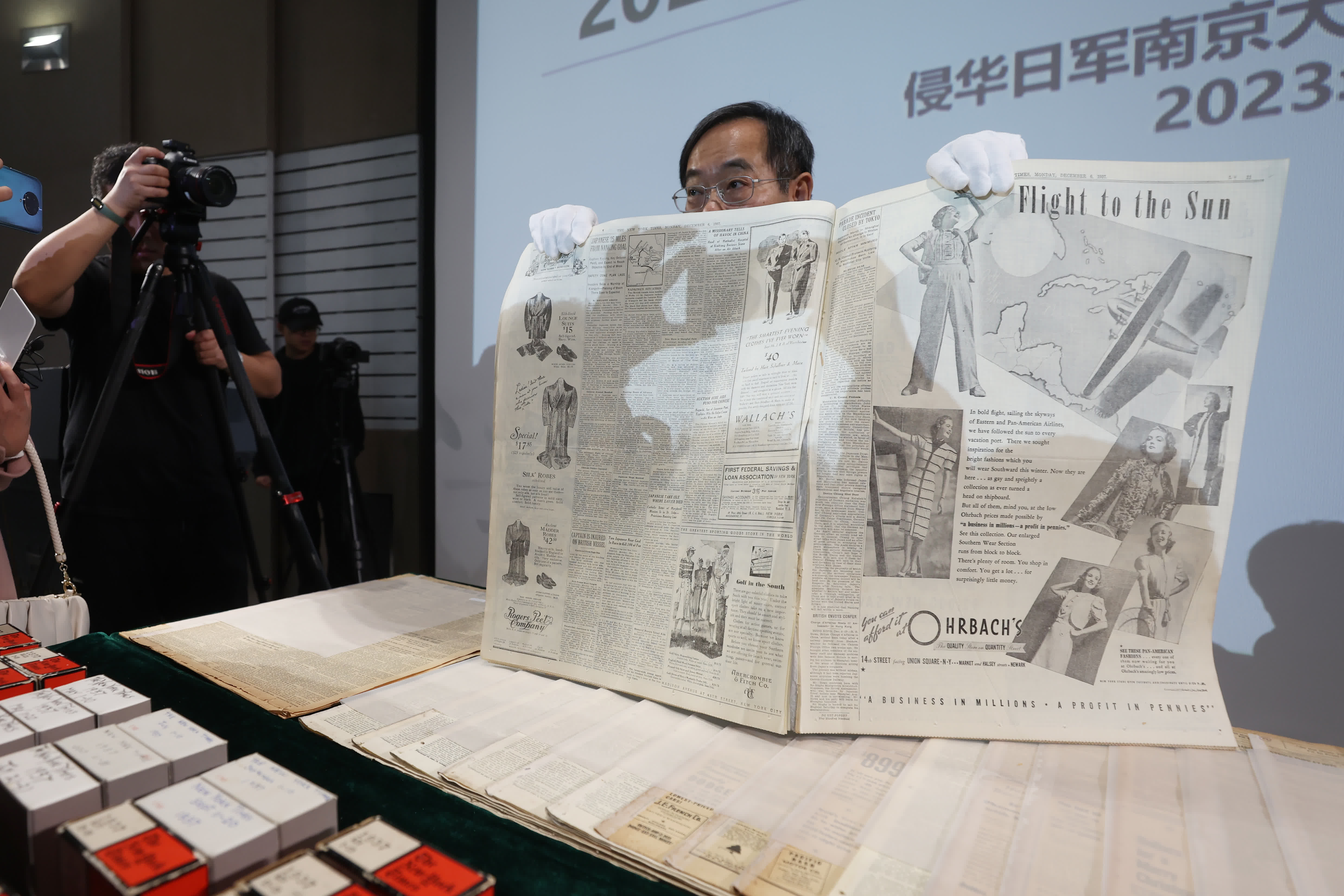 圖為美籍華人魯照寧向媒體展示1937年12月6日出版的紐約時報，報紙對侵華日軍進攻南京做了詳細報道。（中新社）
