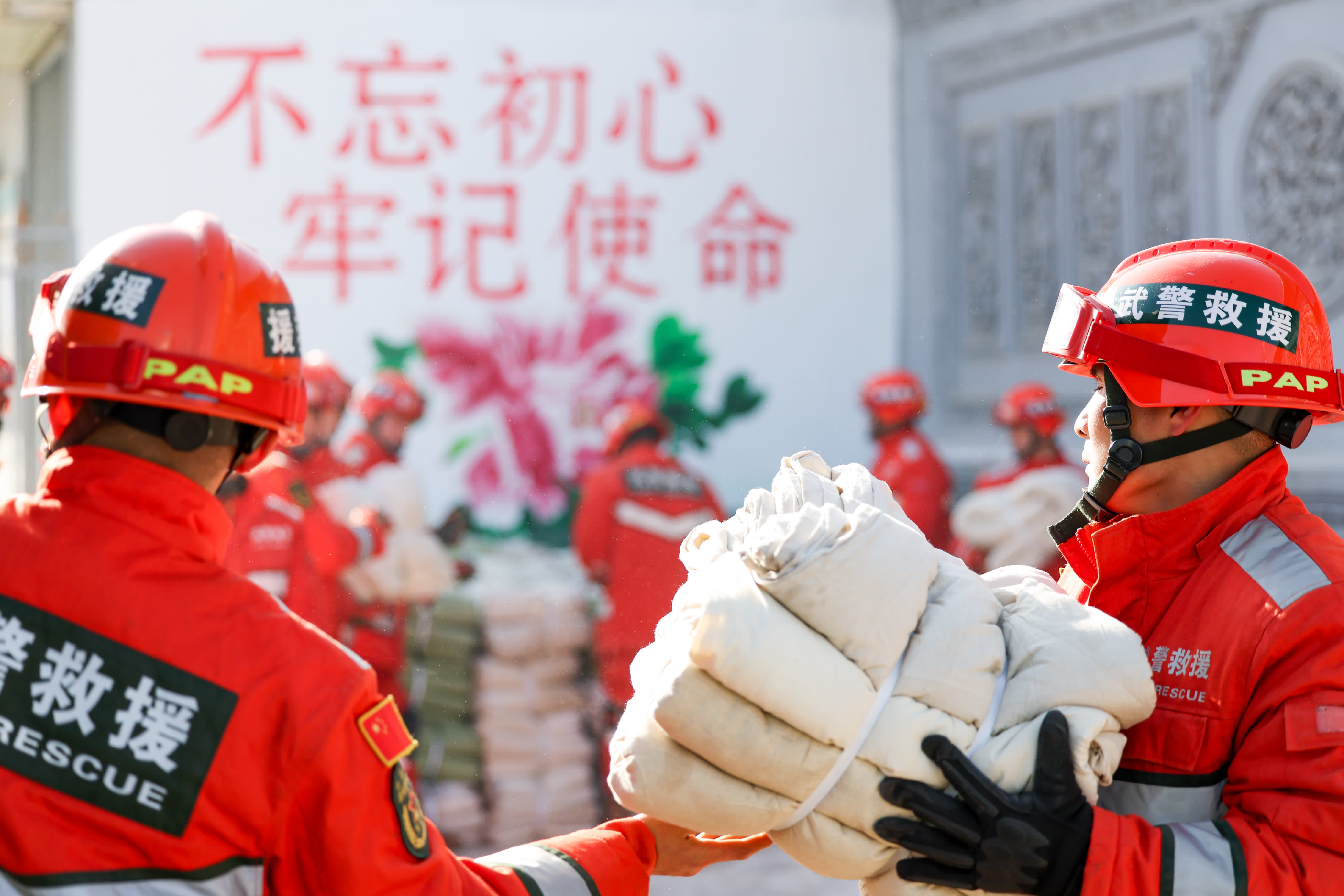 12月20日，武警甘肅總隊機動支隊官兵在積石山縣劉集鄉肖家村為災民提供禦寒物資。（新華社）