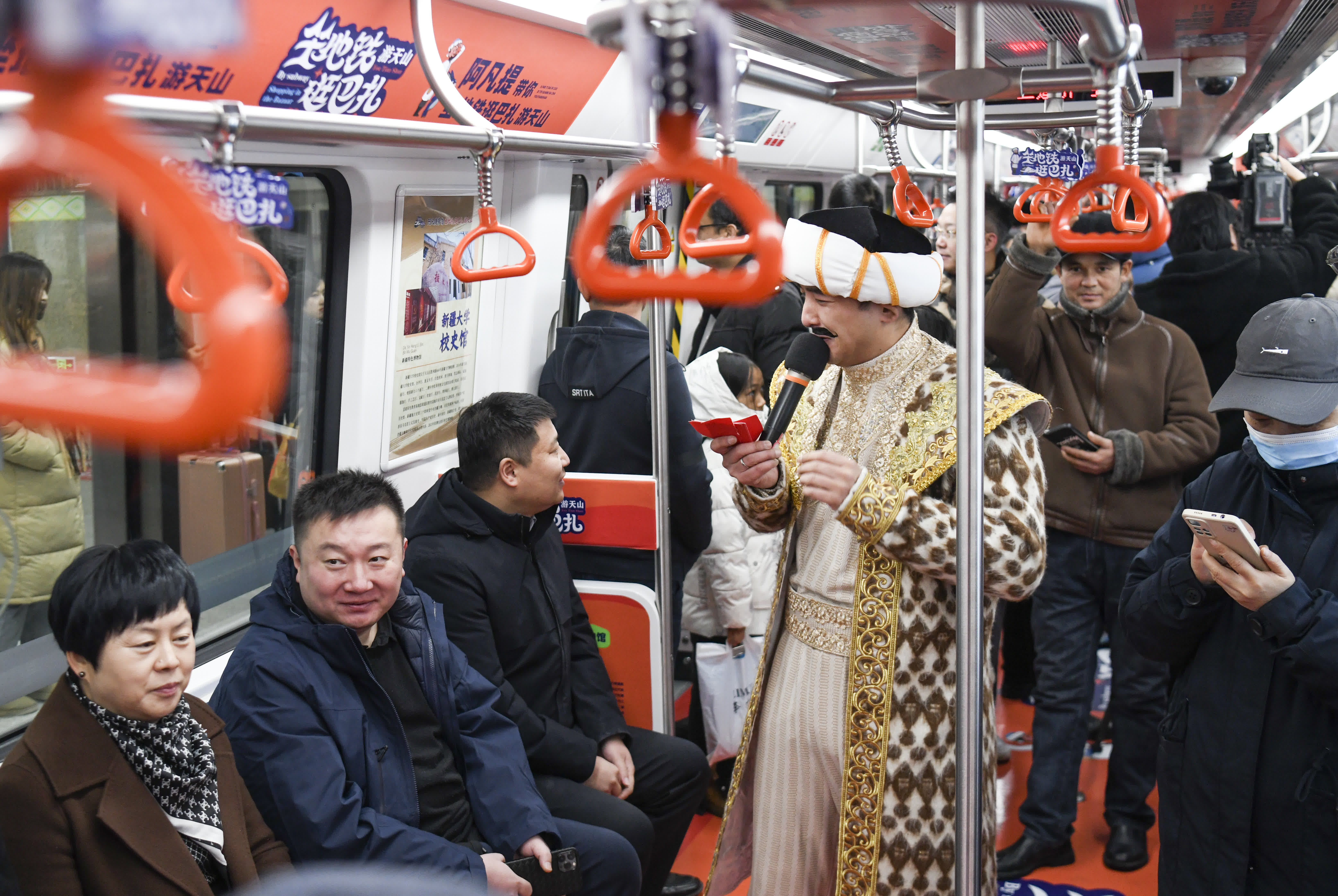 12月23日，在「阿凡提」號地鐵專列中，飾演「阿凡提」的演員與乘客互動。（新華社）