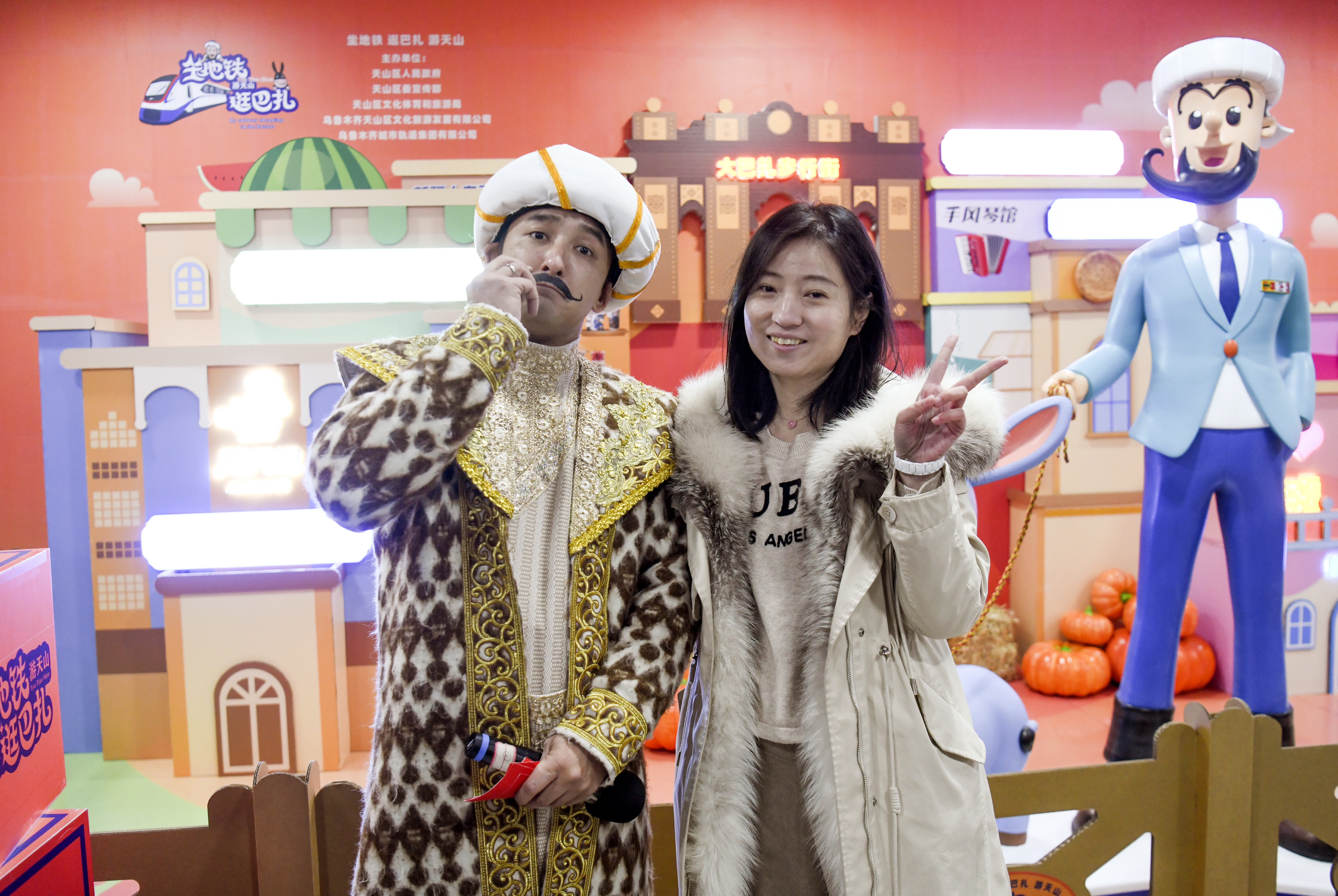 12月23日，在烏魯木齊二道橋地鐵站，乘客與飾演「阿凡提」的演員合影留念。（新華社）