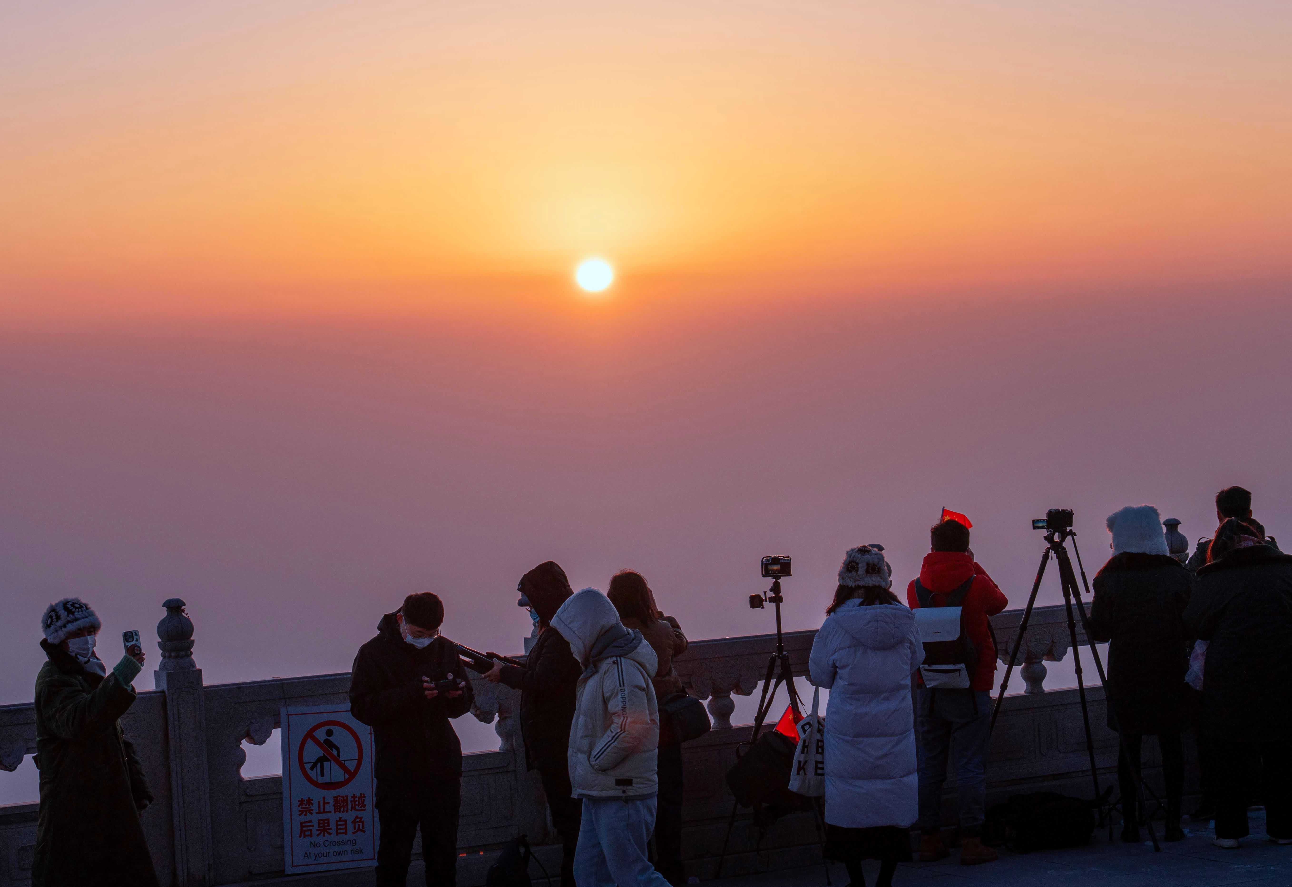 2024年1月1日，在山東省臨沂市沂蒙山銀座天蒙旅遊區，遊客拍攝朝霞。（新華社）