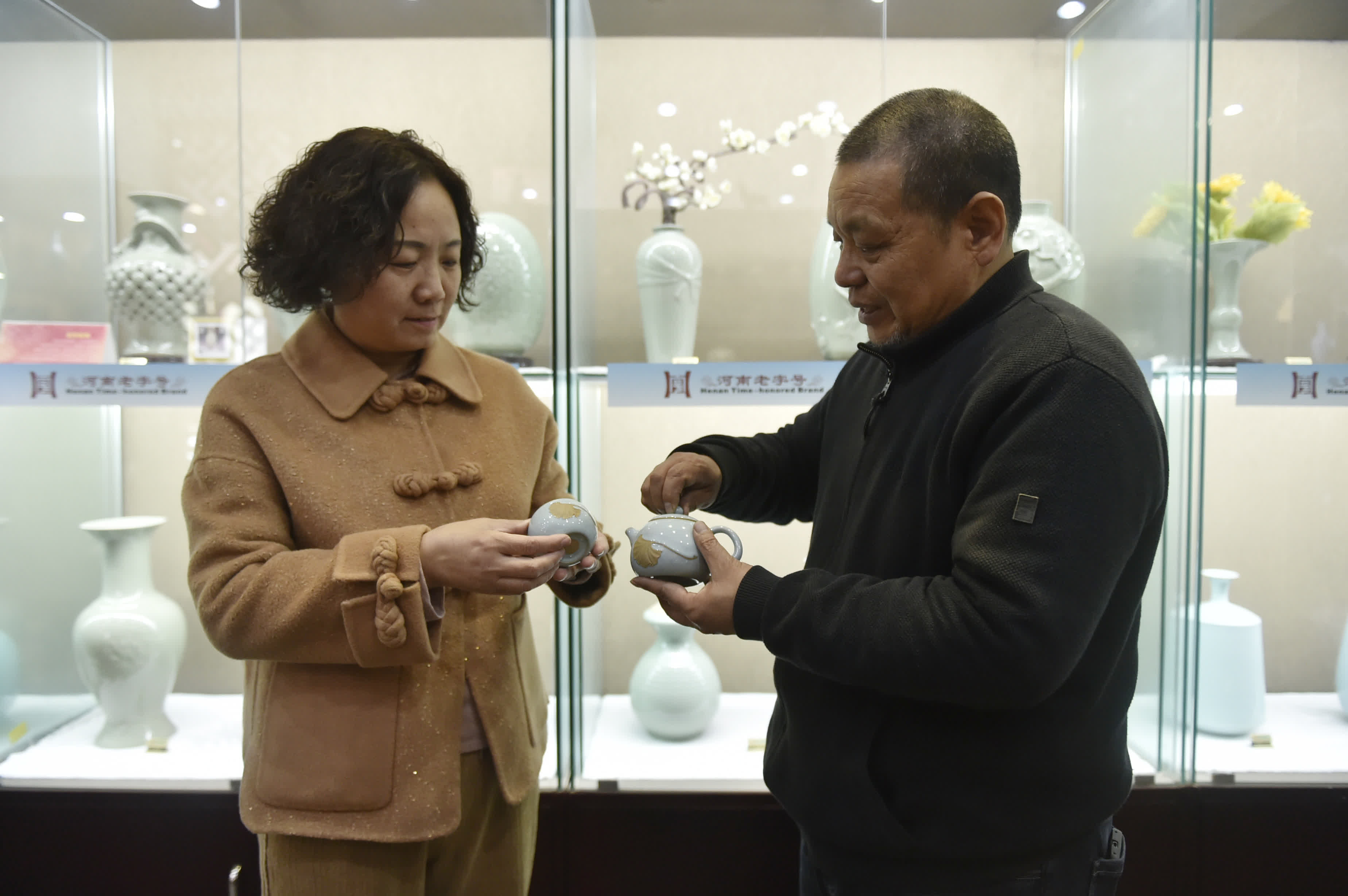 1月10日，范隨州（右）和王振芳在汝州市弘寶汝窯展廳交流共同研發的汝瓷作品。（新華社）