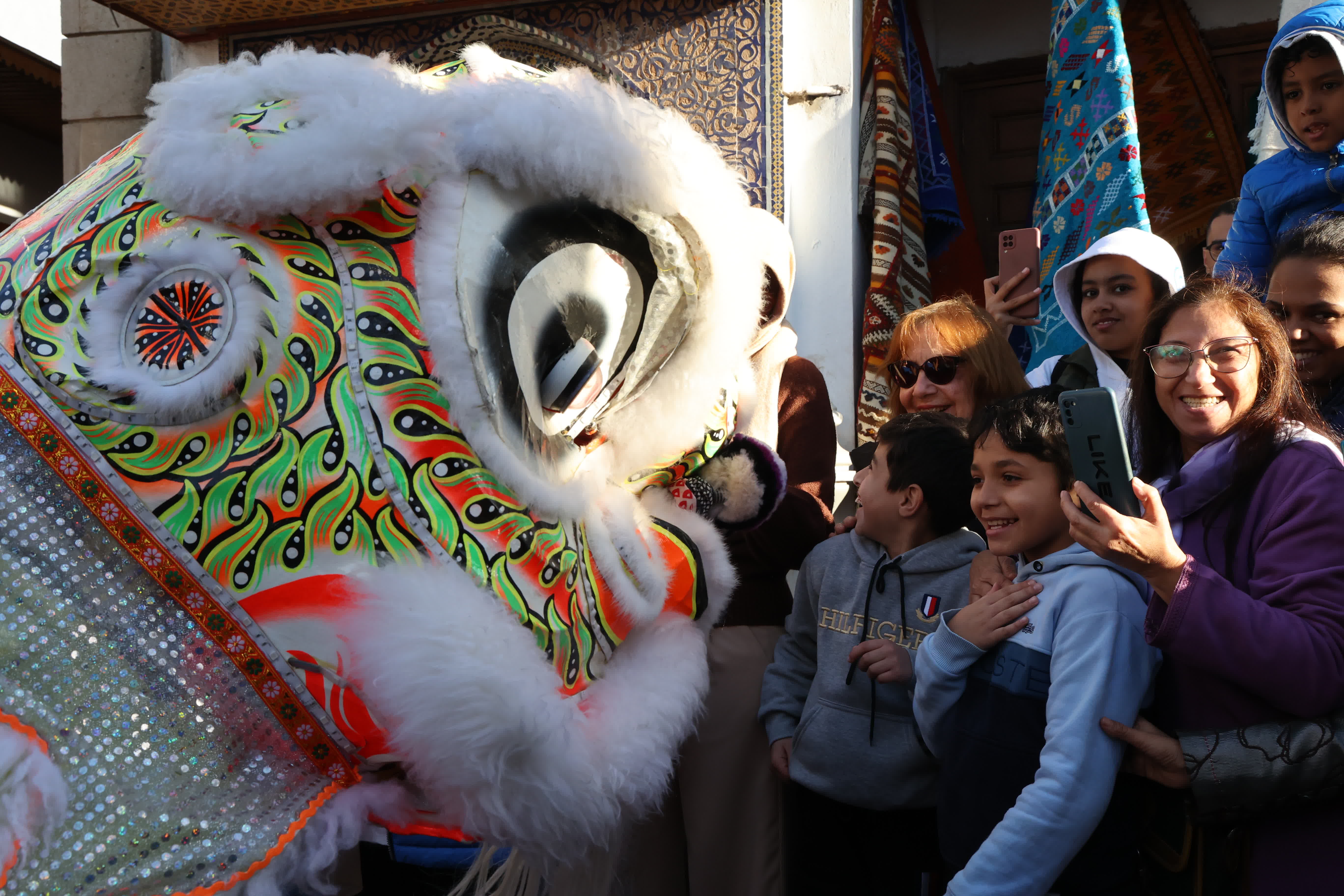  1月22日，在摩洛哥首都拉巴特老城，孩子們和舞獅演員互動。（新華社）