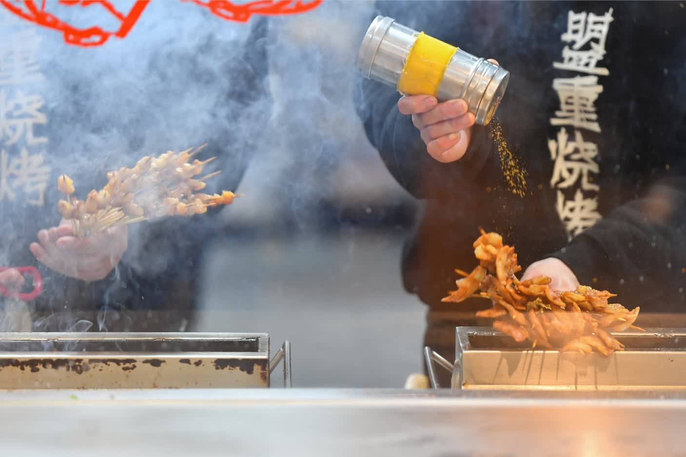 在長沙市天心區裕南街街道的東瓜山夜市美食一條街，一家燒烤店的員工在烤串（2月4日攝）。（新華社）