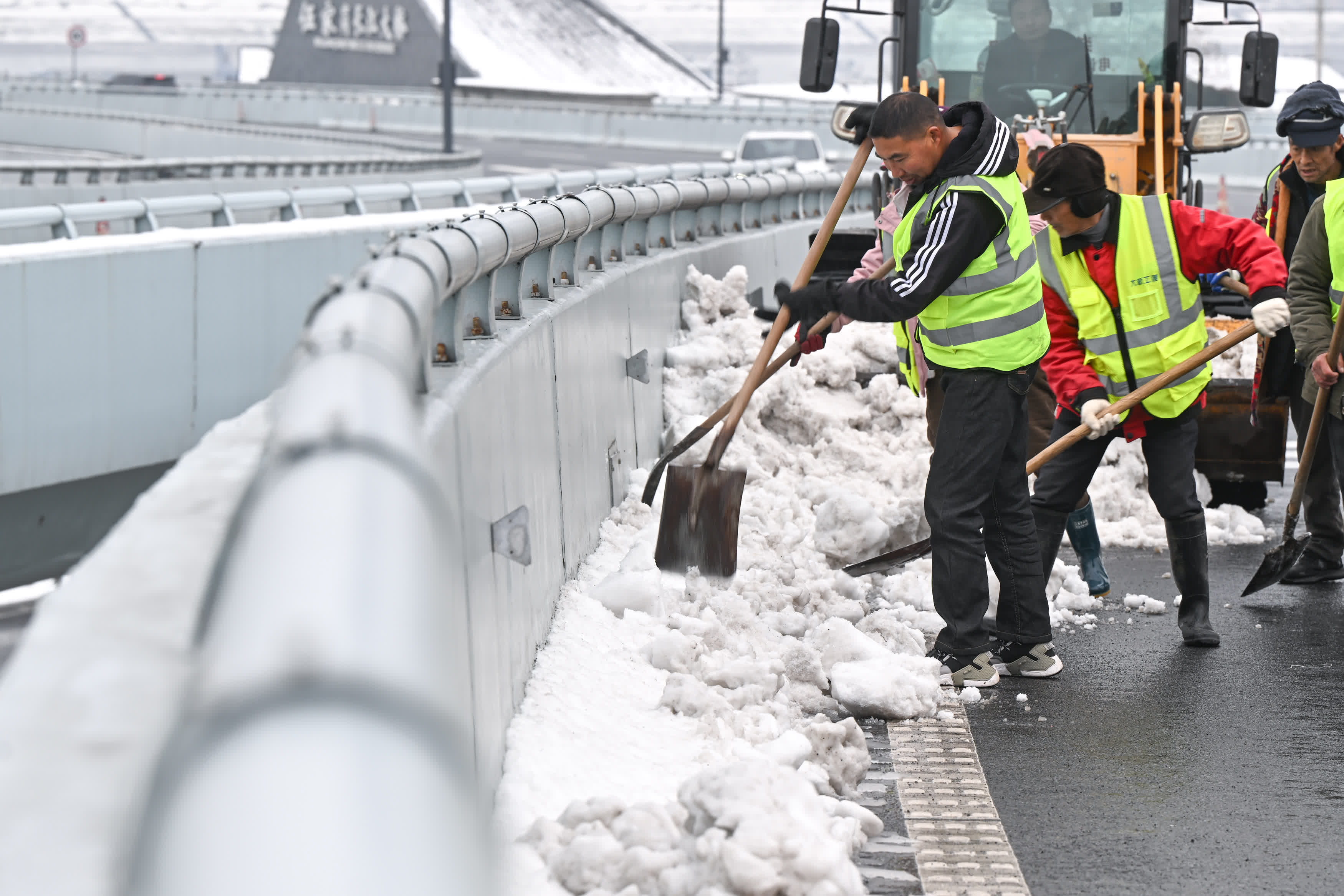 2月6日，宜昌城發集團工作人員在伍家崗長江大橋進行鏟雪作業。（新華社）
