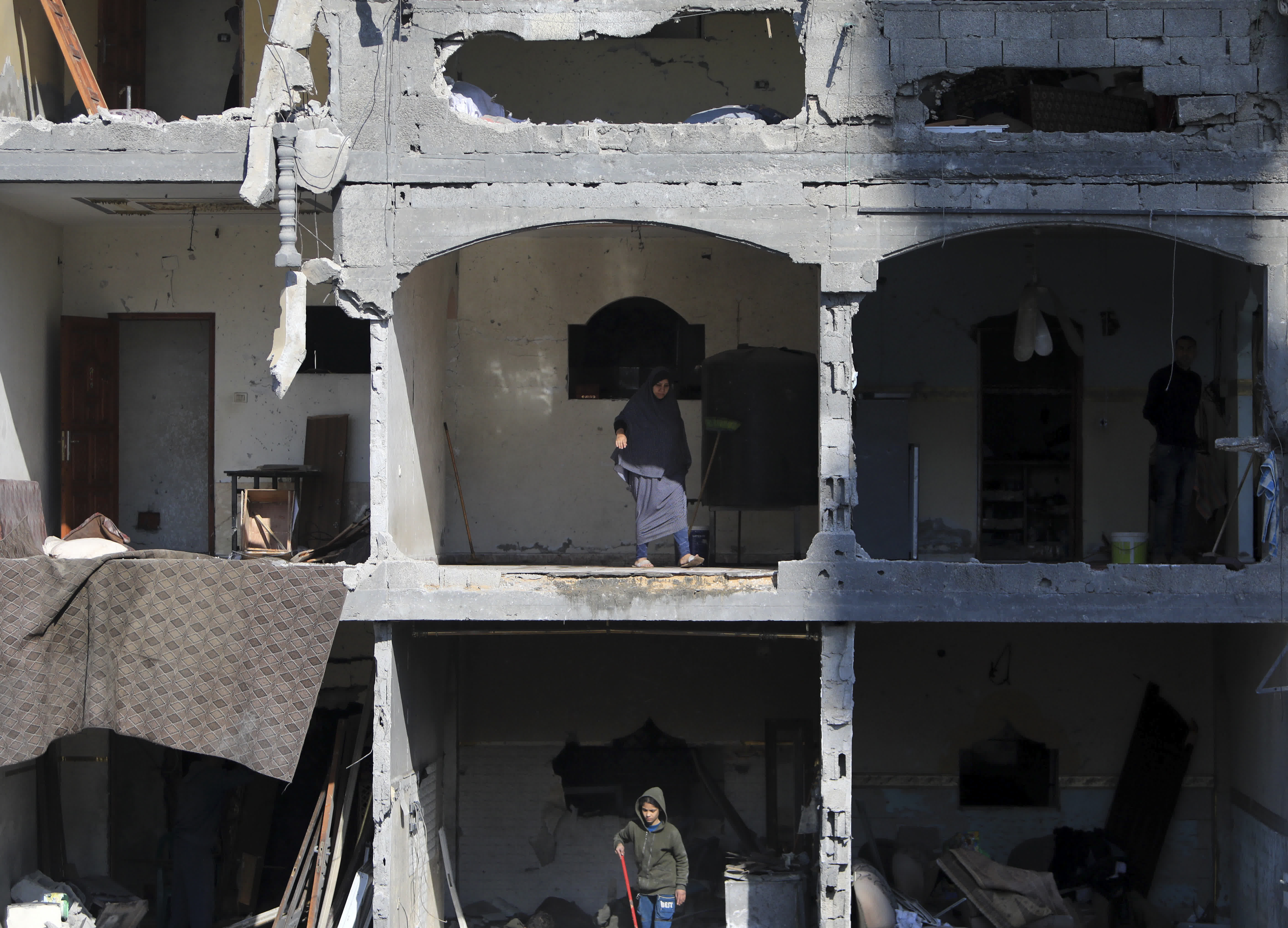 2月22日，人們查看加沙地帶南部城市拉法一處在以軍襲擊中損毀的建築。（新華社）