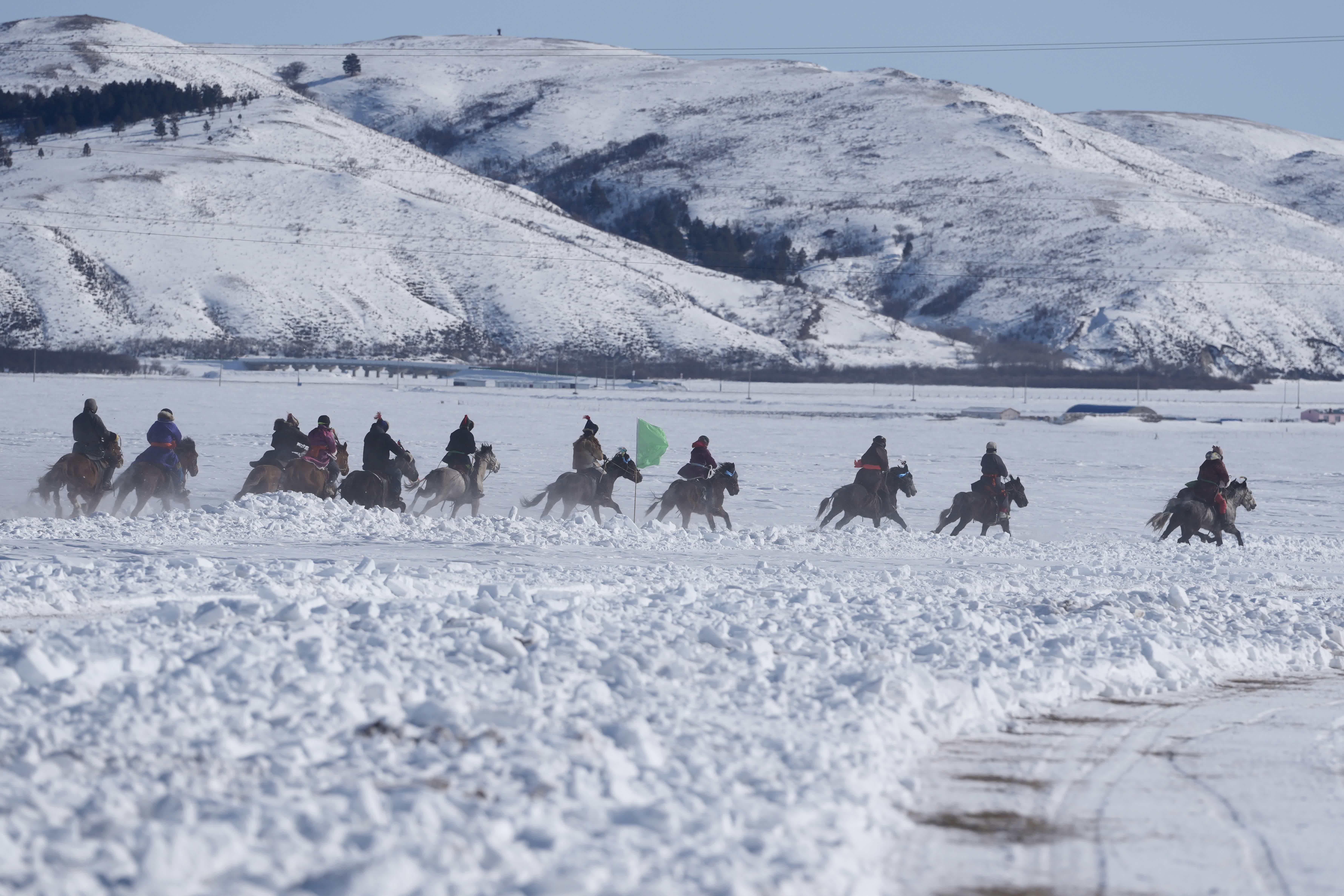 圖為選手們騎馬在雪原上飛馳。（中新社）