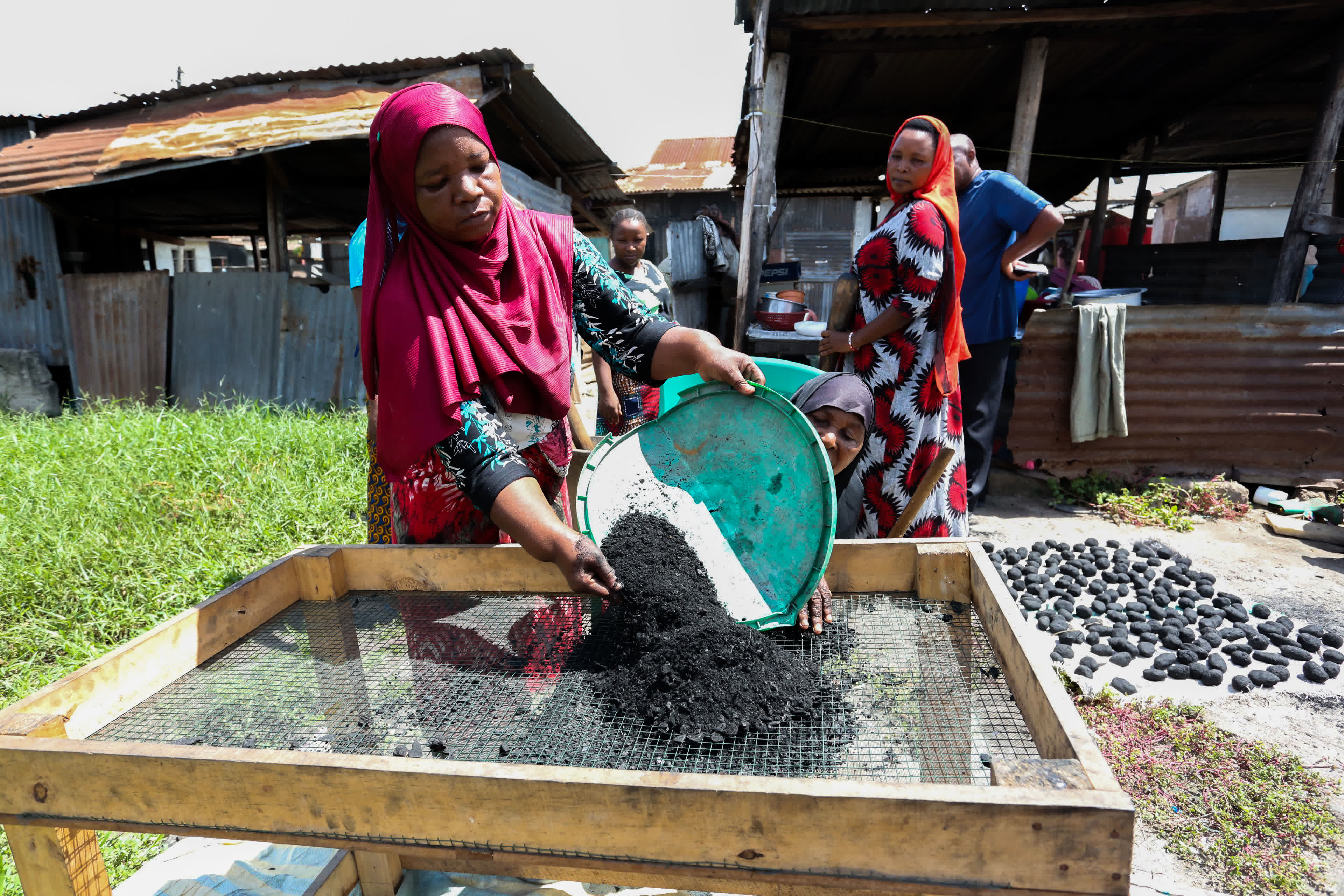 3月16日，在坦桑尼亞達累斯薩拉姆，當地婦女製作生物質燃料。新華社