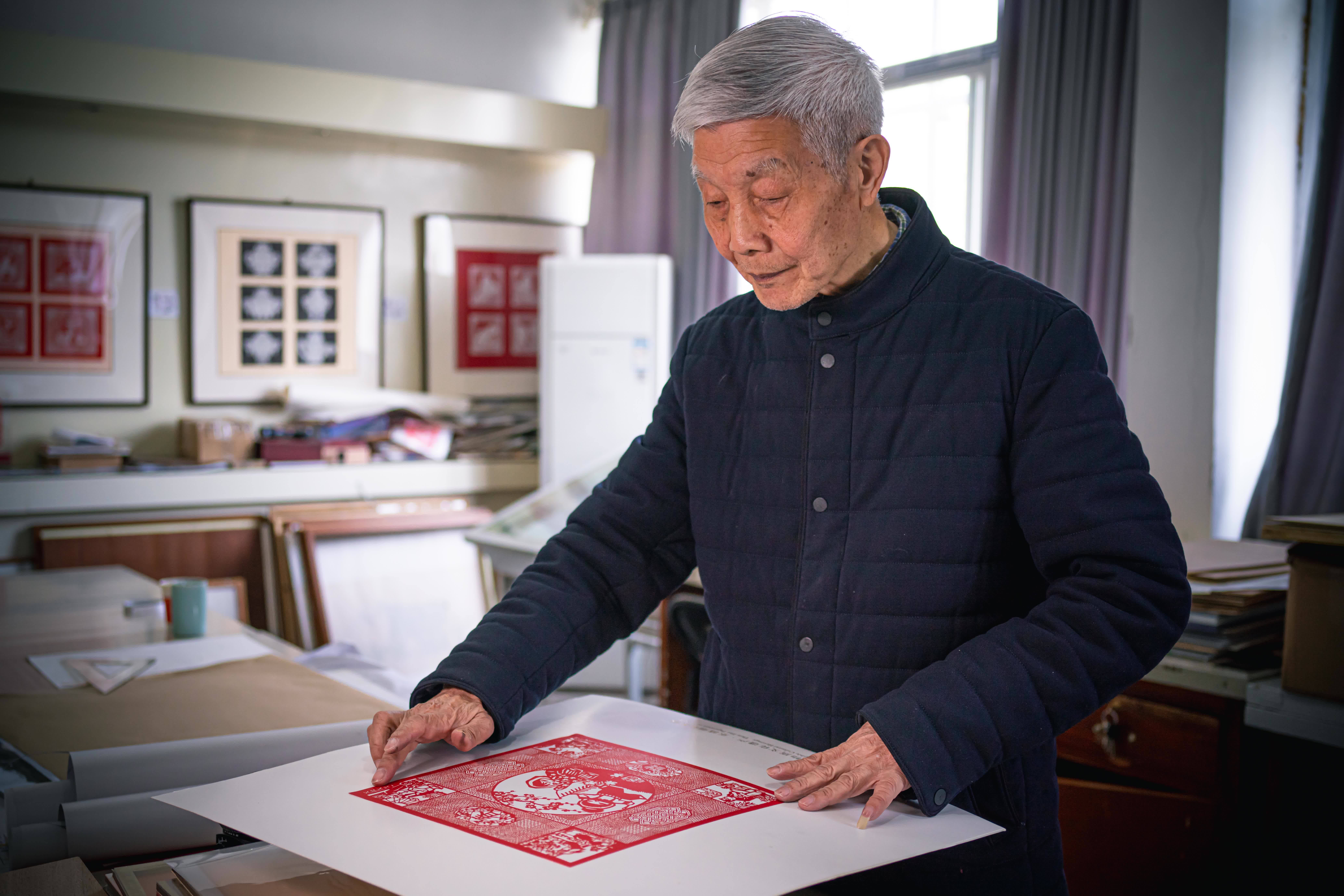 盧發良在工作室內裝裱一幅細紋刻紙作品（3月12日攝）。（新華社）