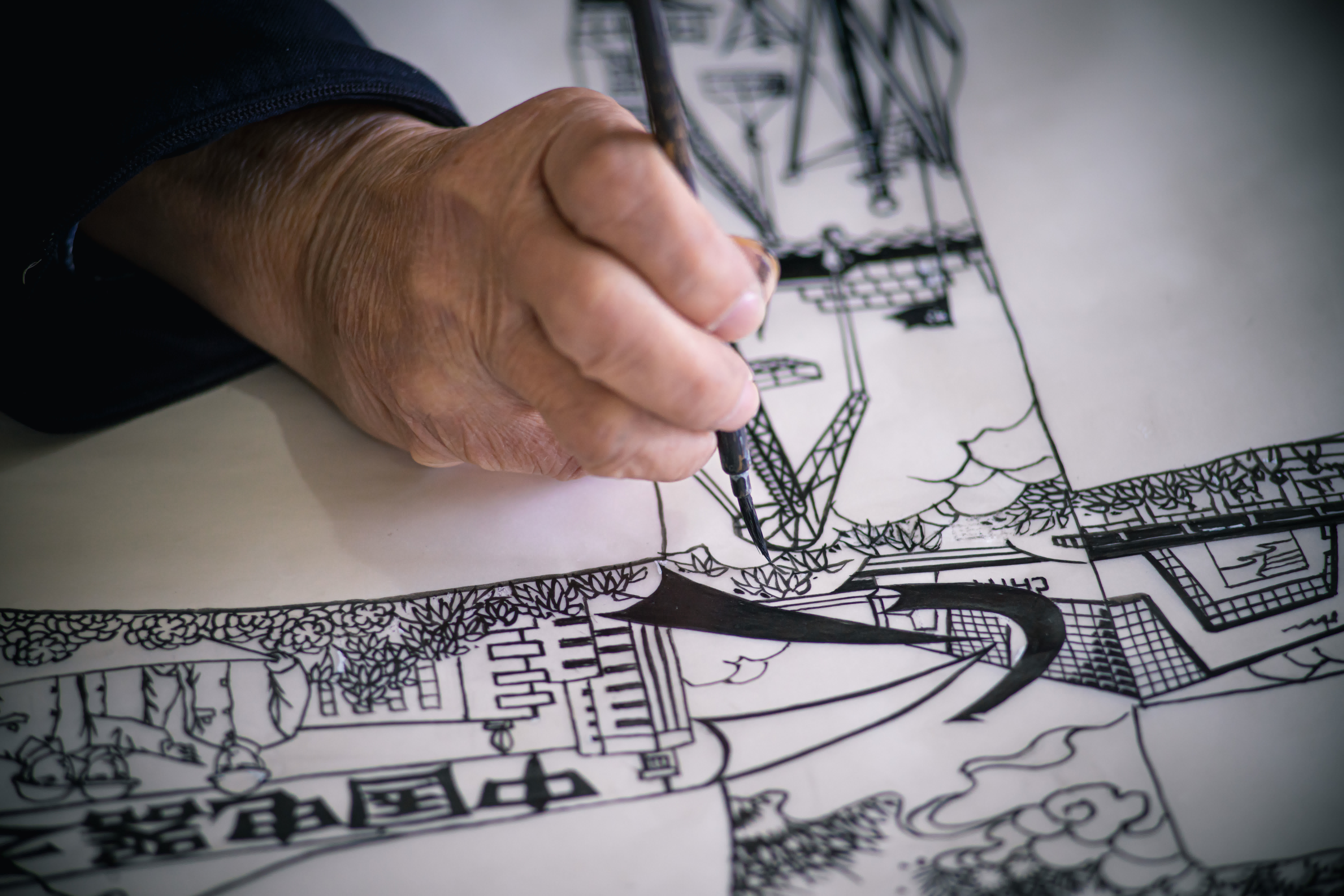 盧發良在工作室內設計一幅以樂清城市特色為主題的細紋刻紙畫稿（3月12日攝）。（新華社）