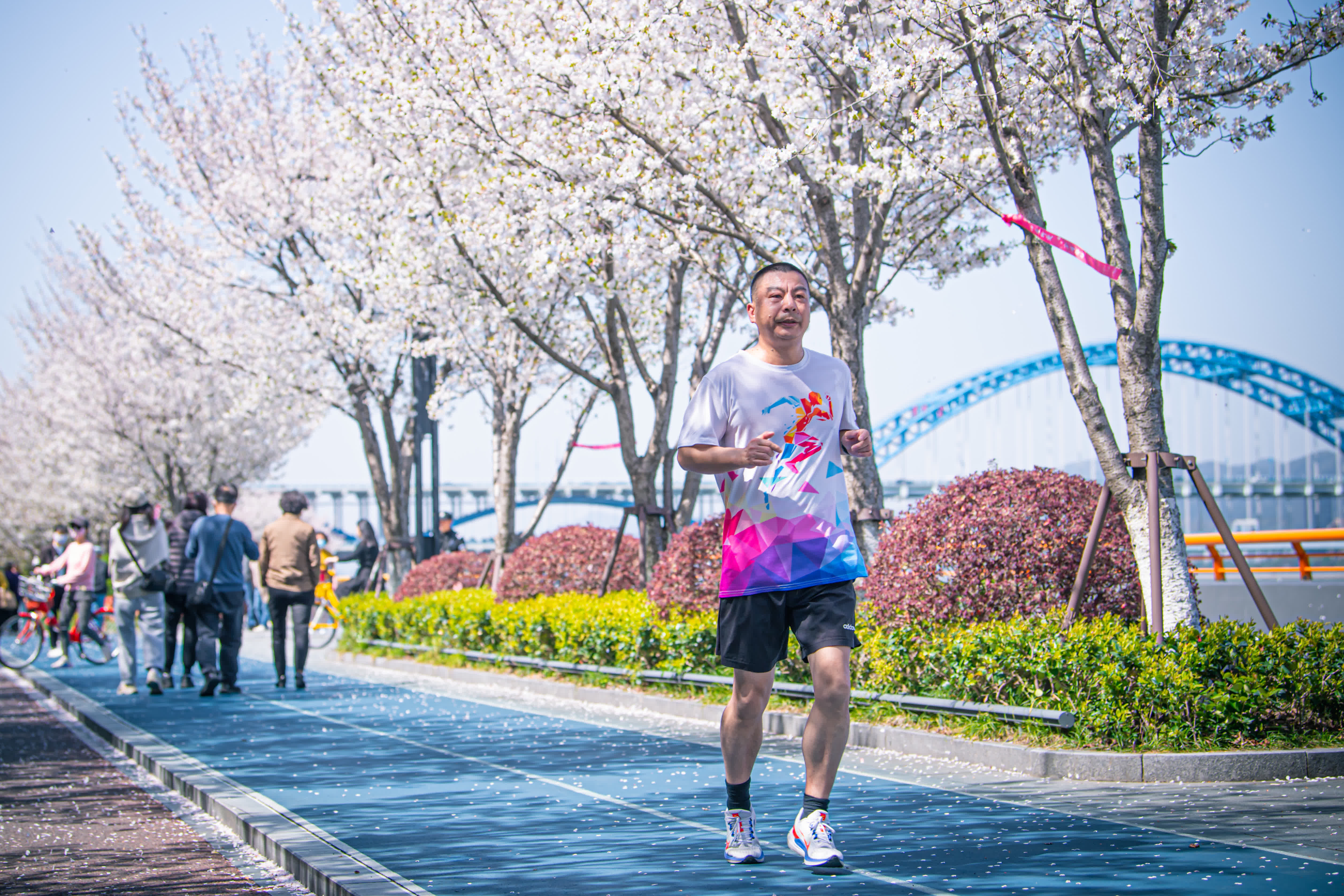3月29日，市民在杭州市濱江區沿江綠道「櫻花跑道」上跑步鍛鍊。（新華社）