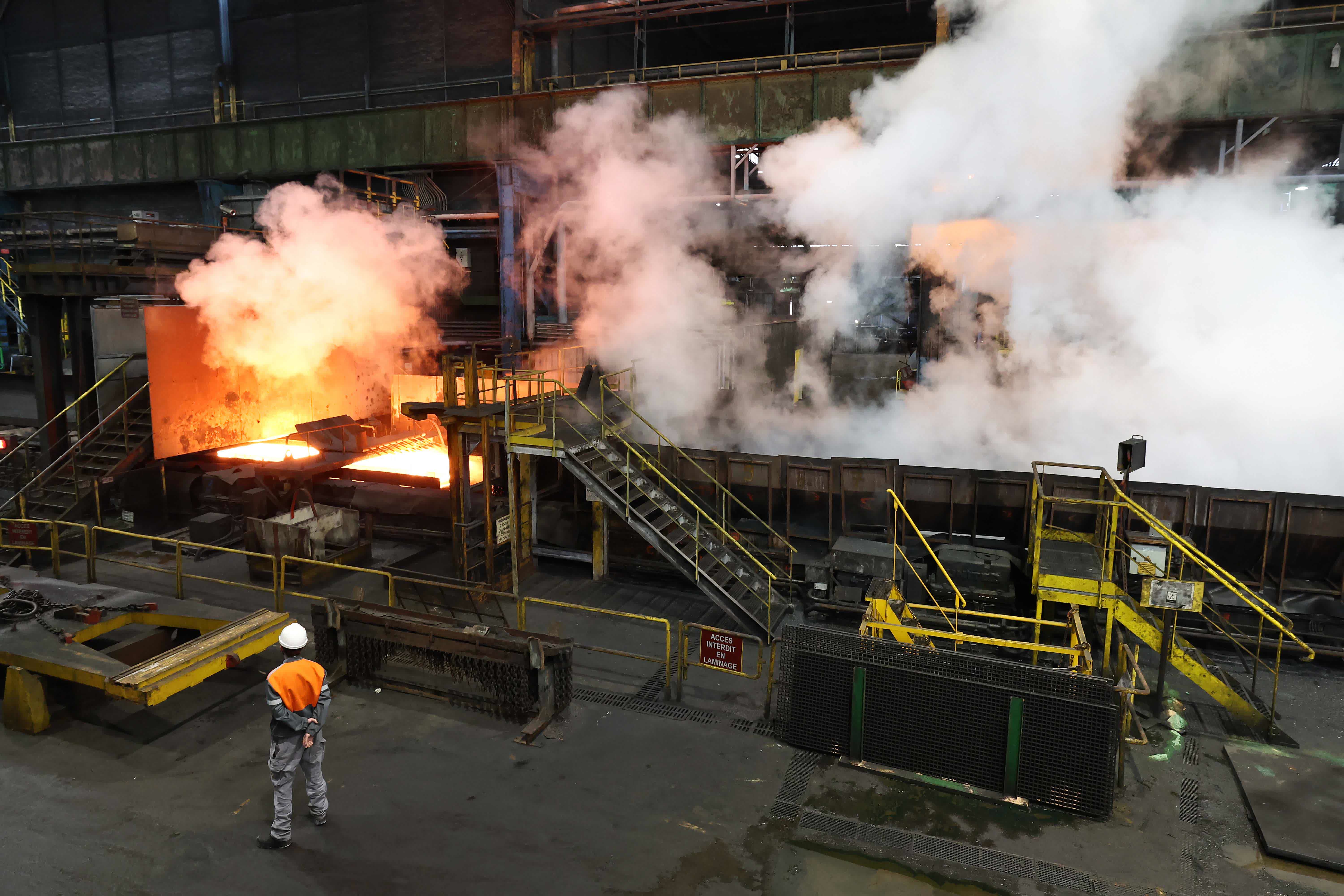 圖為安賽樂米塔爾鋼鐵廠生產用於製造奧運火炬的鋼材時，一塊鋼板通過熱軋機列車冒出濃煙。（法新社）