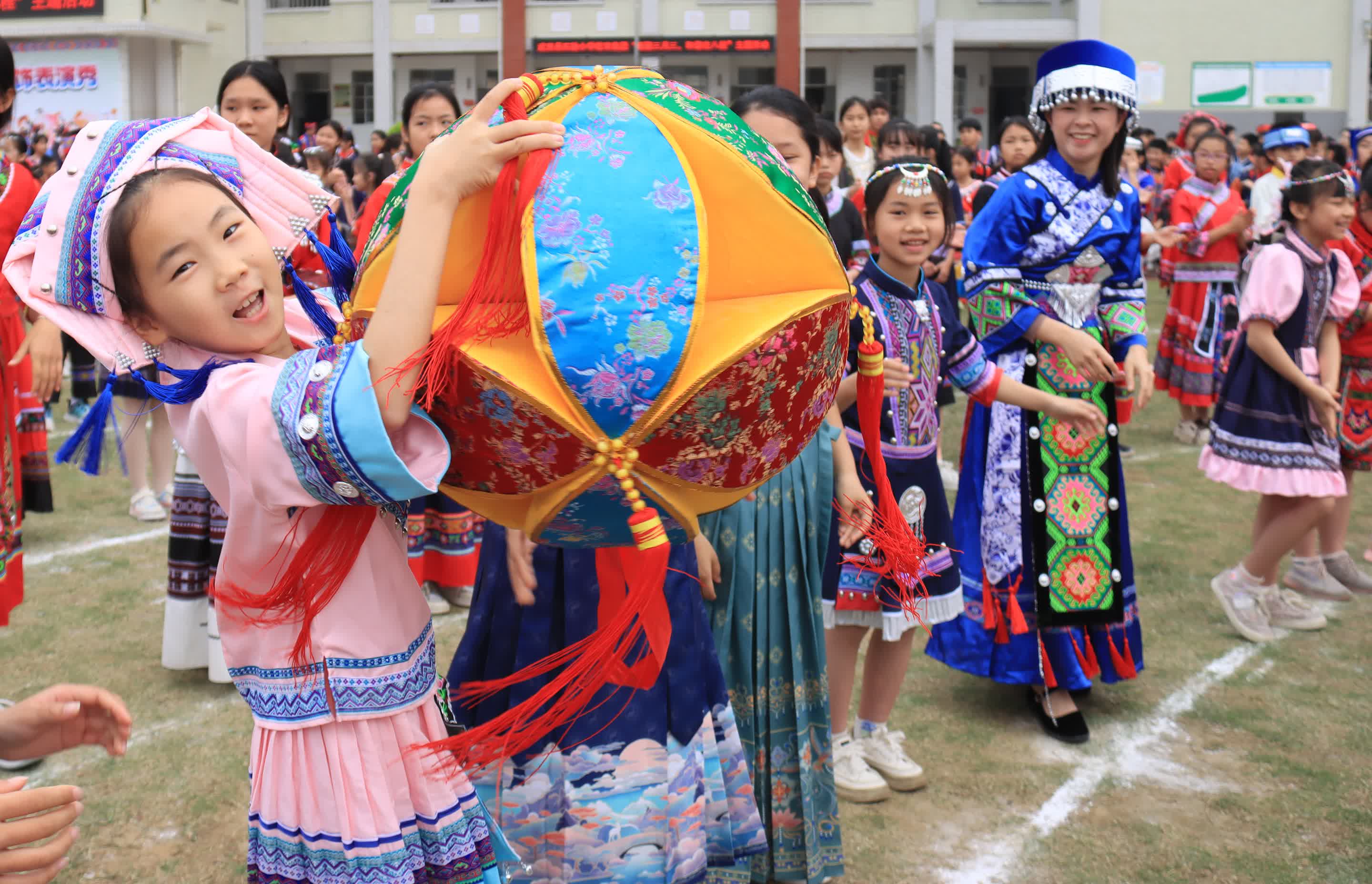 4月9日，在廣西武宣縣實驗小學城南校區，師生在傳遞繡球。（新華社）