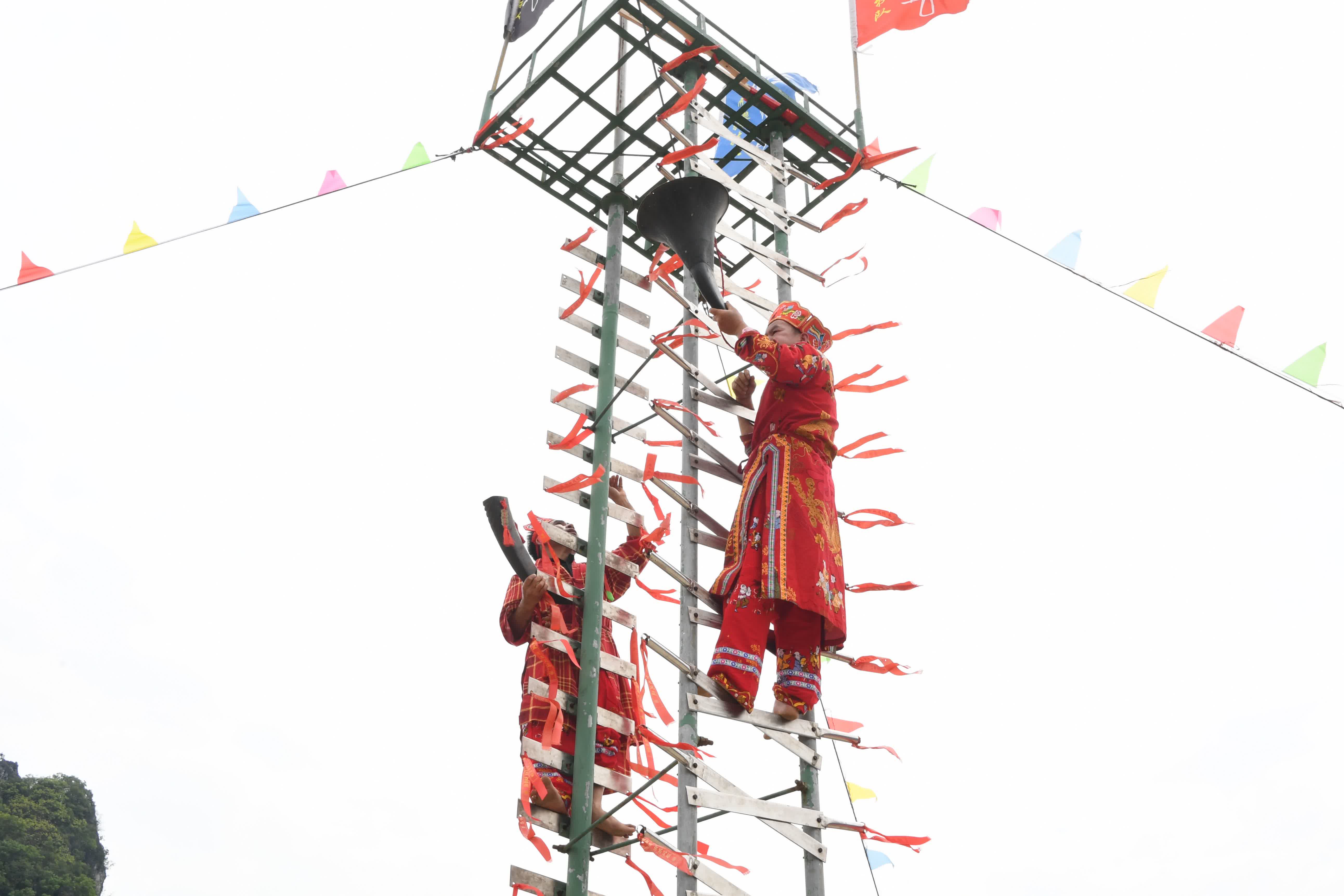4月9日，在廣西河池市羅城仫佬族自治縣成龍湖廣場，民間藝人在表演「上刀山」技藝。（新華社）