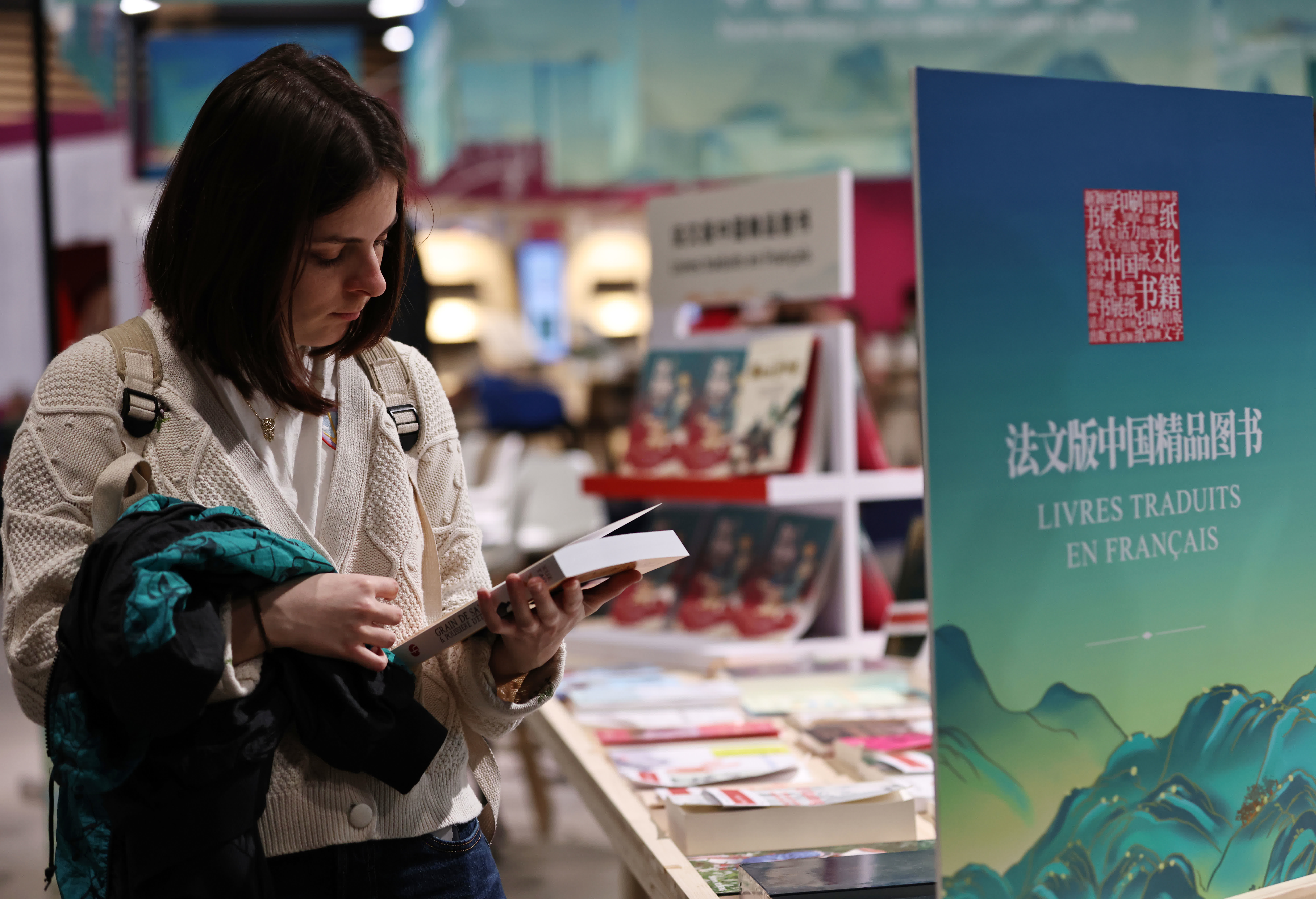 4月12日，一名女子在法國巴黎臨時大皇宮舉行的2024巴黎書展上翻閱中國圖書。新華社