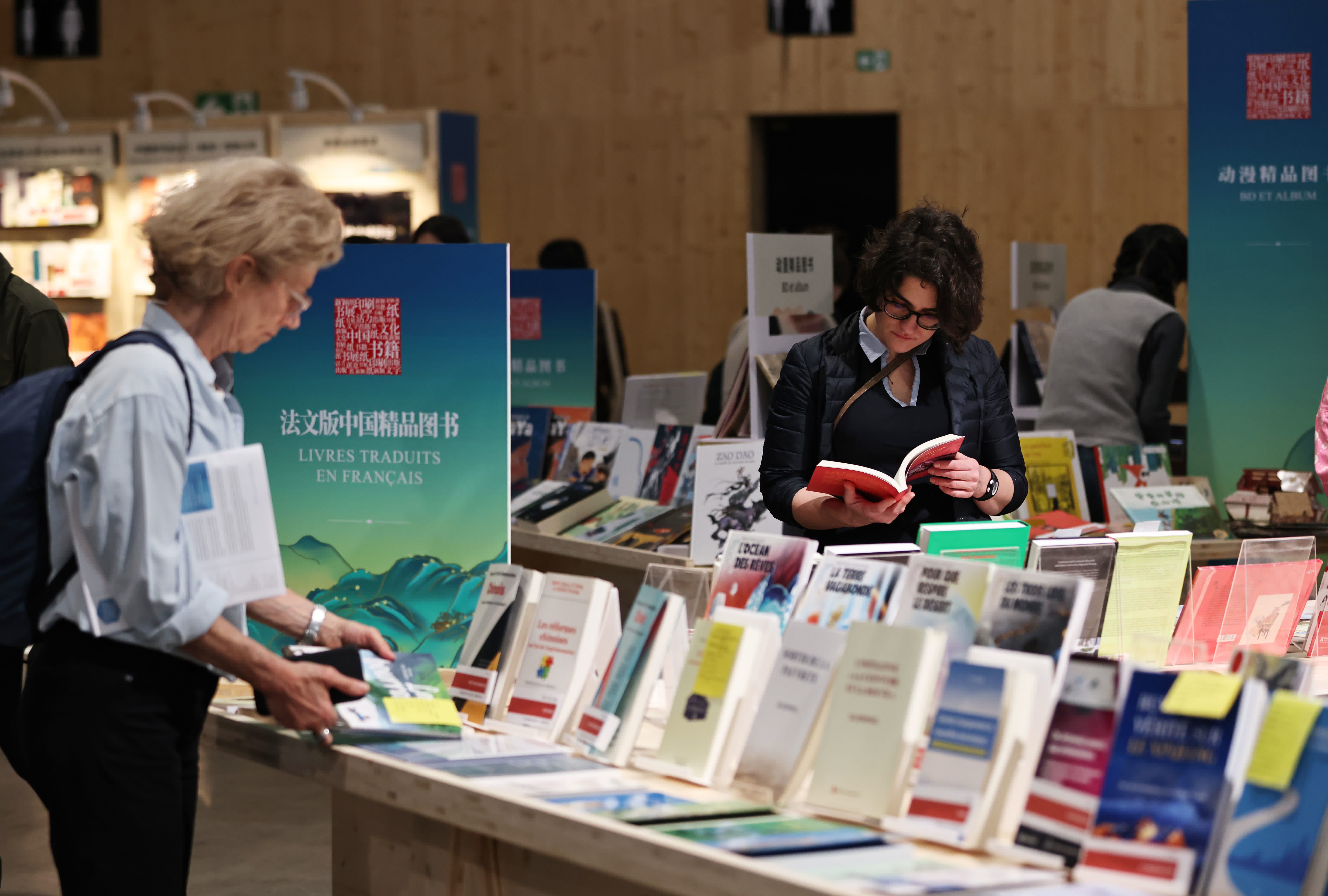 4月12日，人們在法國巴黎臨時大皇宮舉行的2024巴黎書展上翻閱中國圖書。新華社