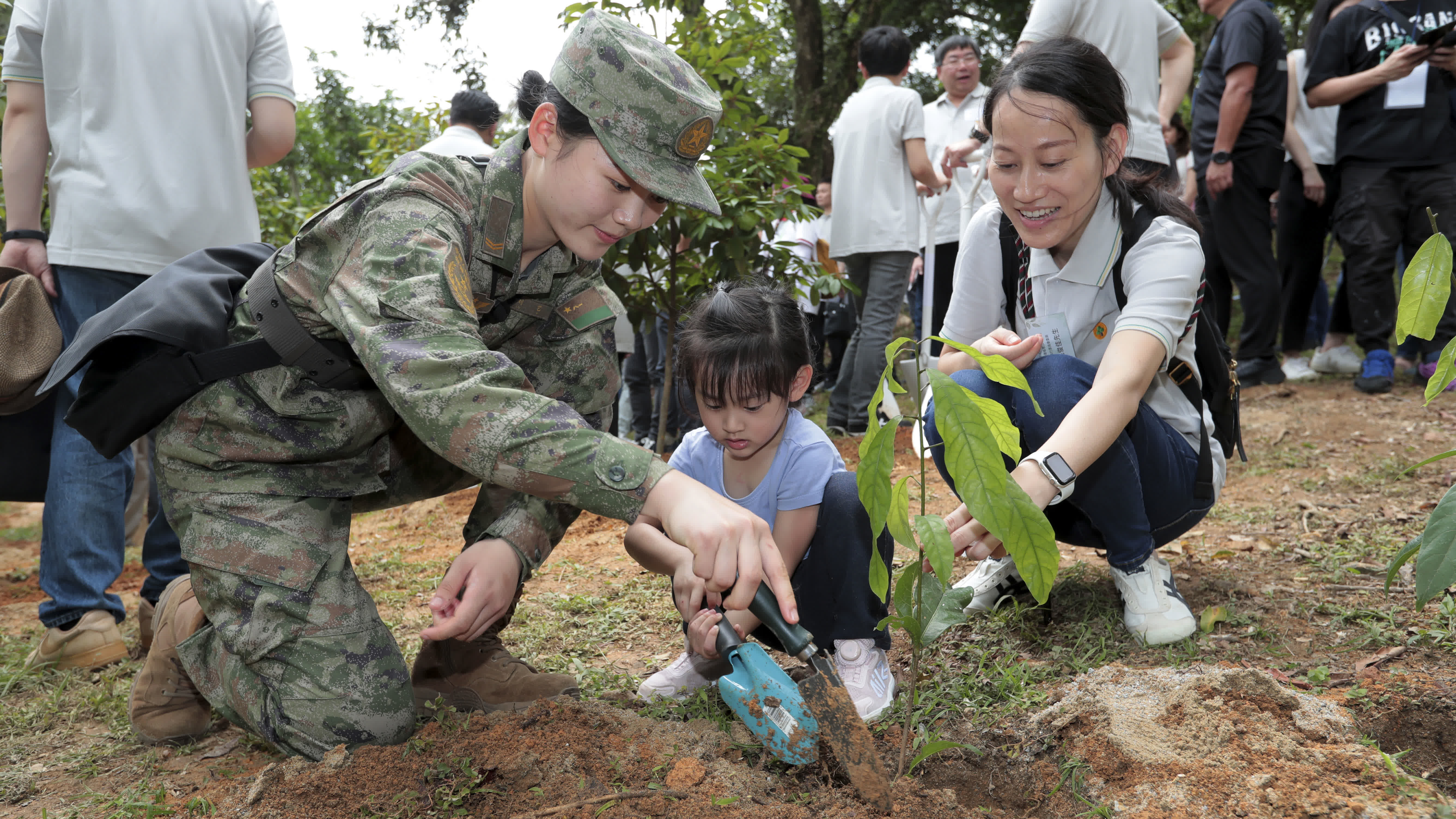 4月20日，駐港部隊官兵代表與香港小朋友一起植樹。（新華社）