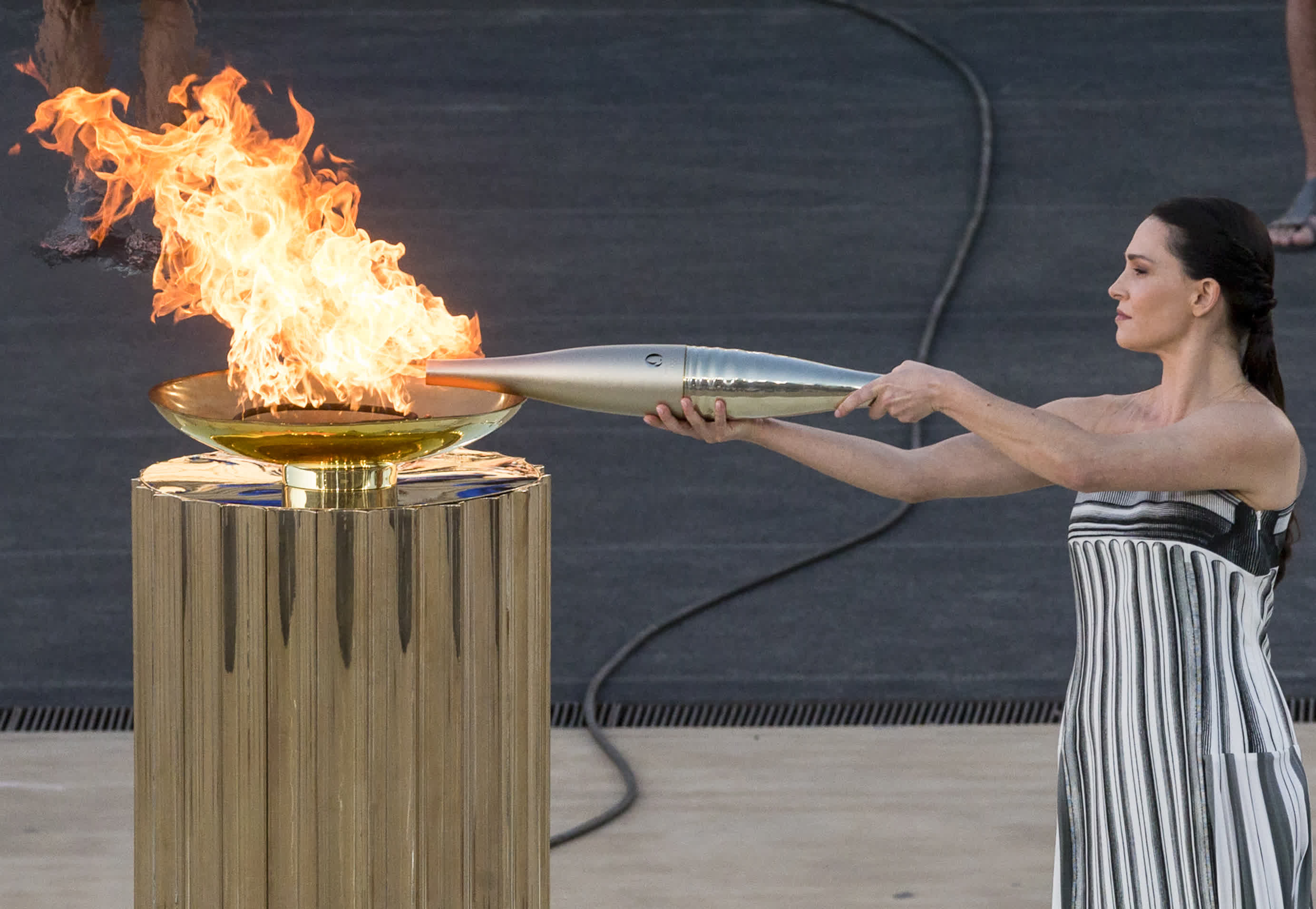 4月26日，扮演最高女祭司的希臘女演員瑪麗·米娜用火盆中的火點燃火炬。（新華社）