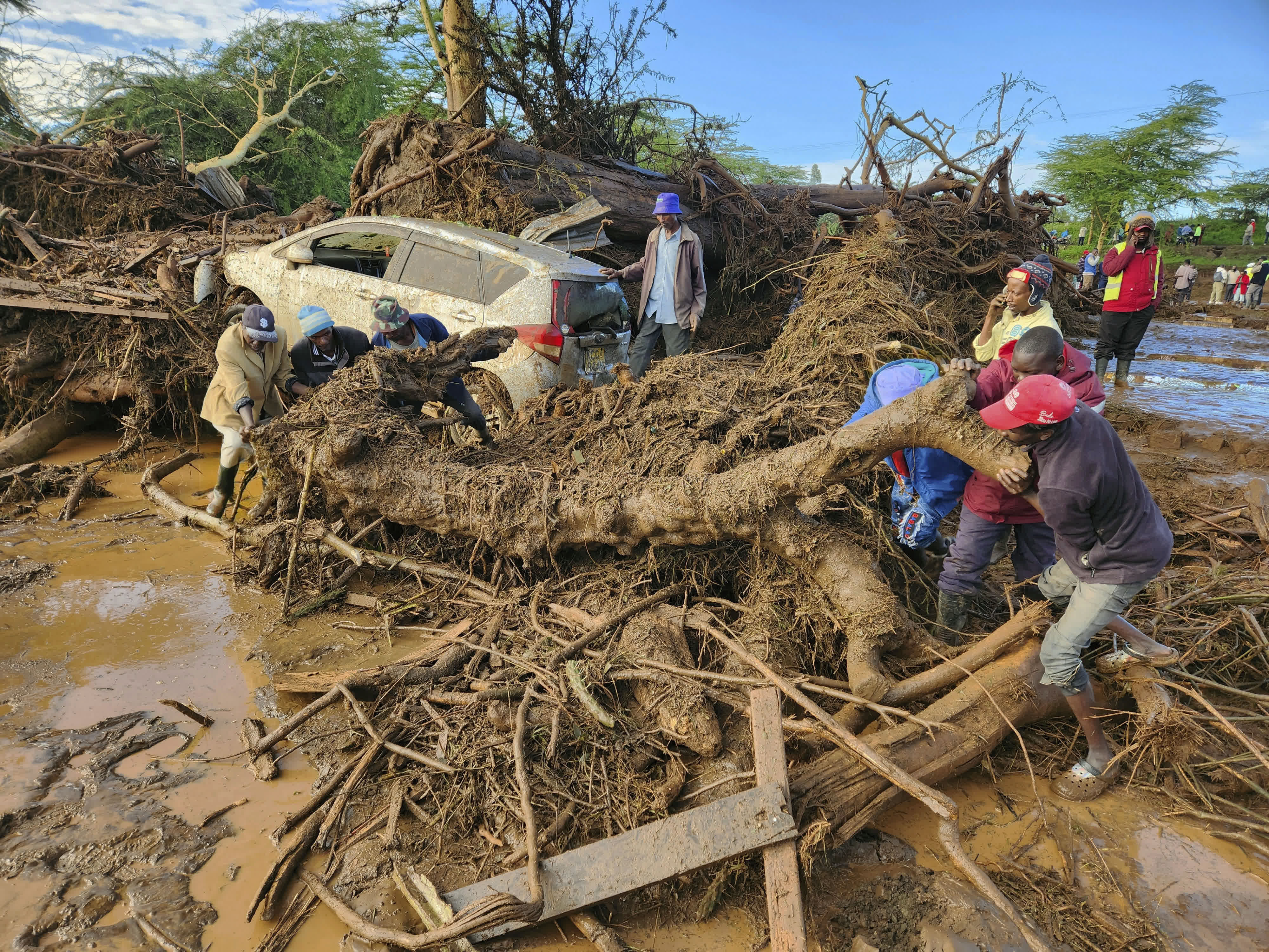 當地時間4月29日，大壩決堤後，肯尼亚納庫魯一村莊民眾進行清淤。（中新社）
