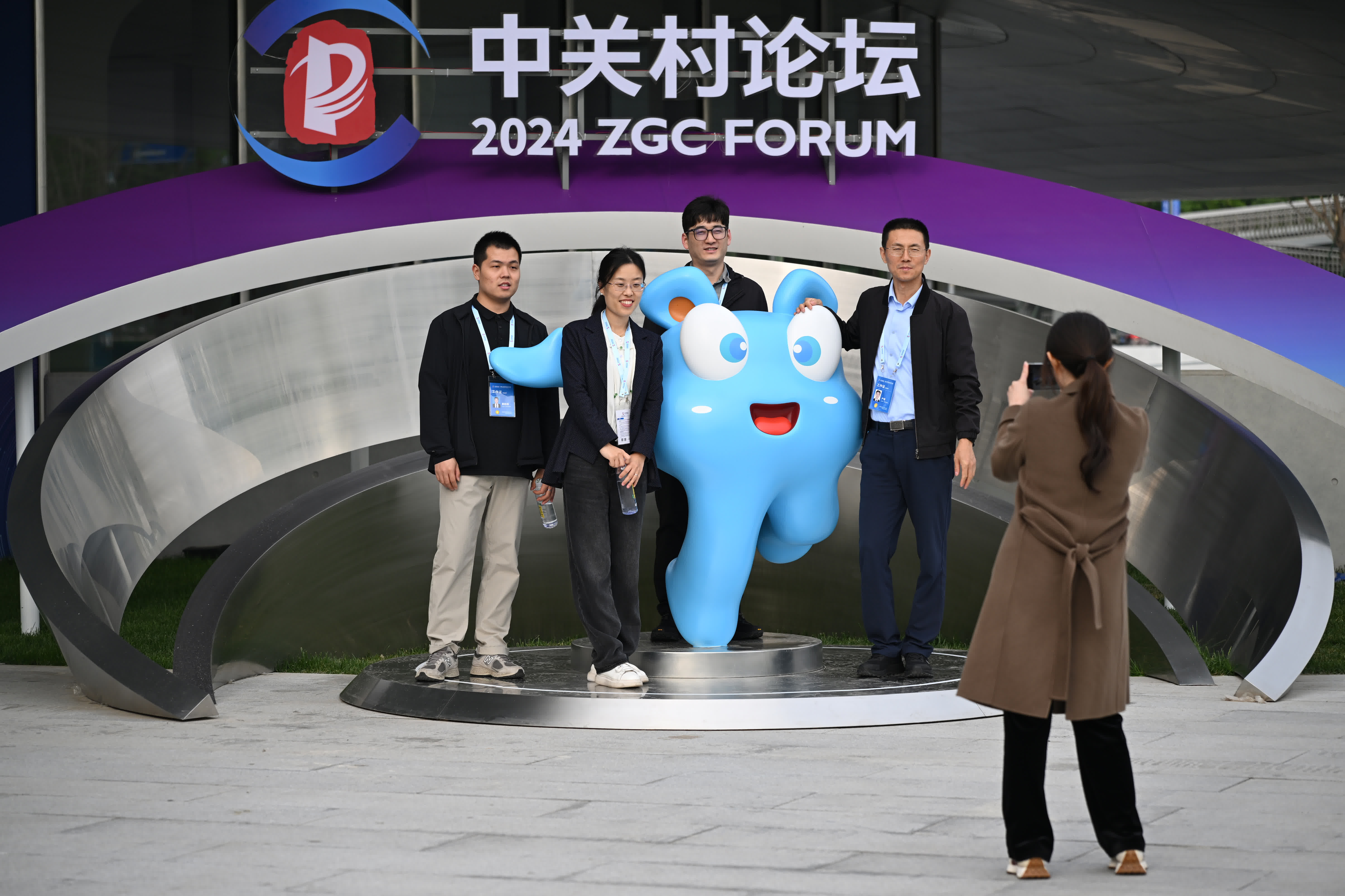 與會者在2024中關村論壇年會一處標識前合影留念。（中新社）