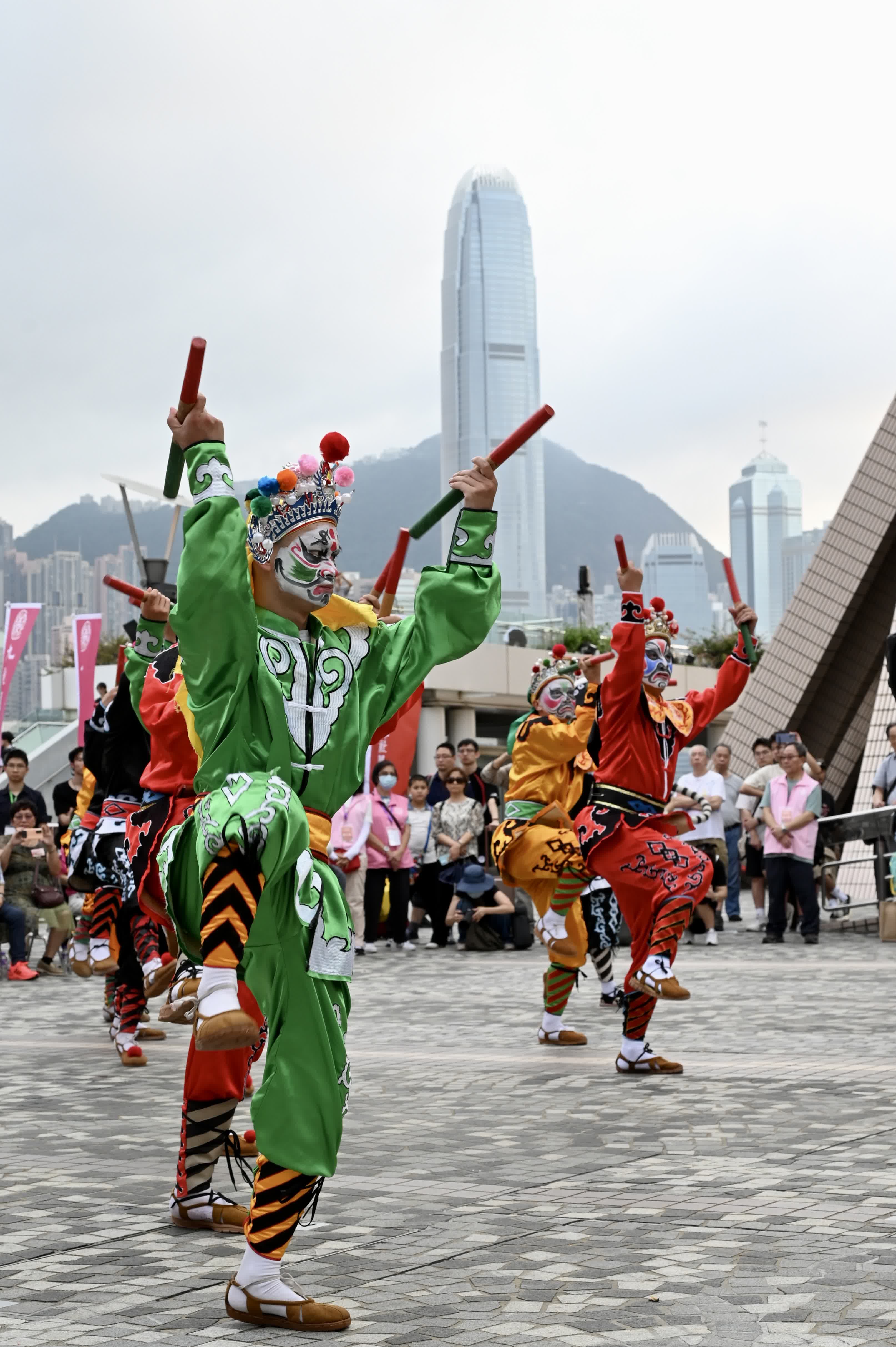 圖為英歌舞表演與遠處的香港國際金融中心大廈。（中新社） 