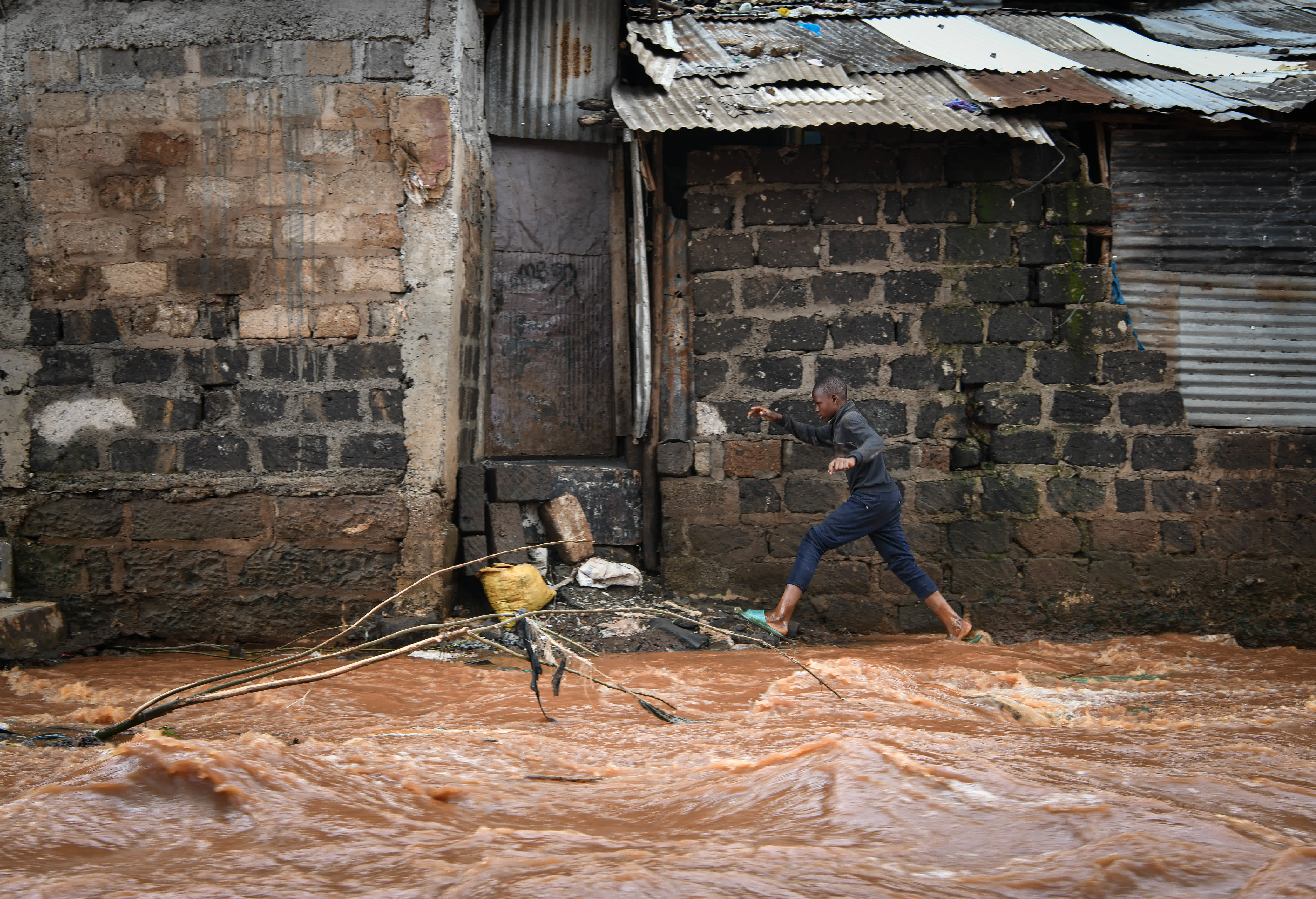 4月30日，一名男孩在肯尼亞首都內羅畢的馬薩雷貧民區涉水行走。（新華社）