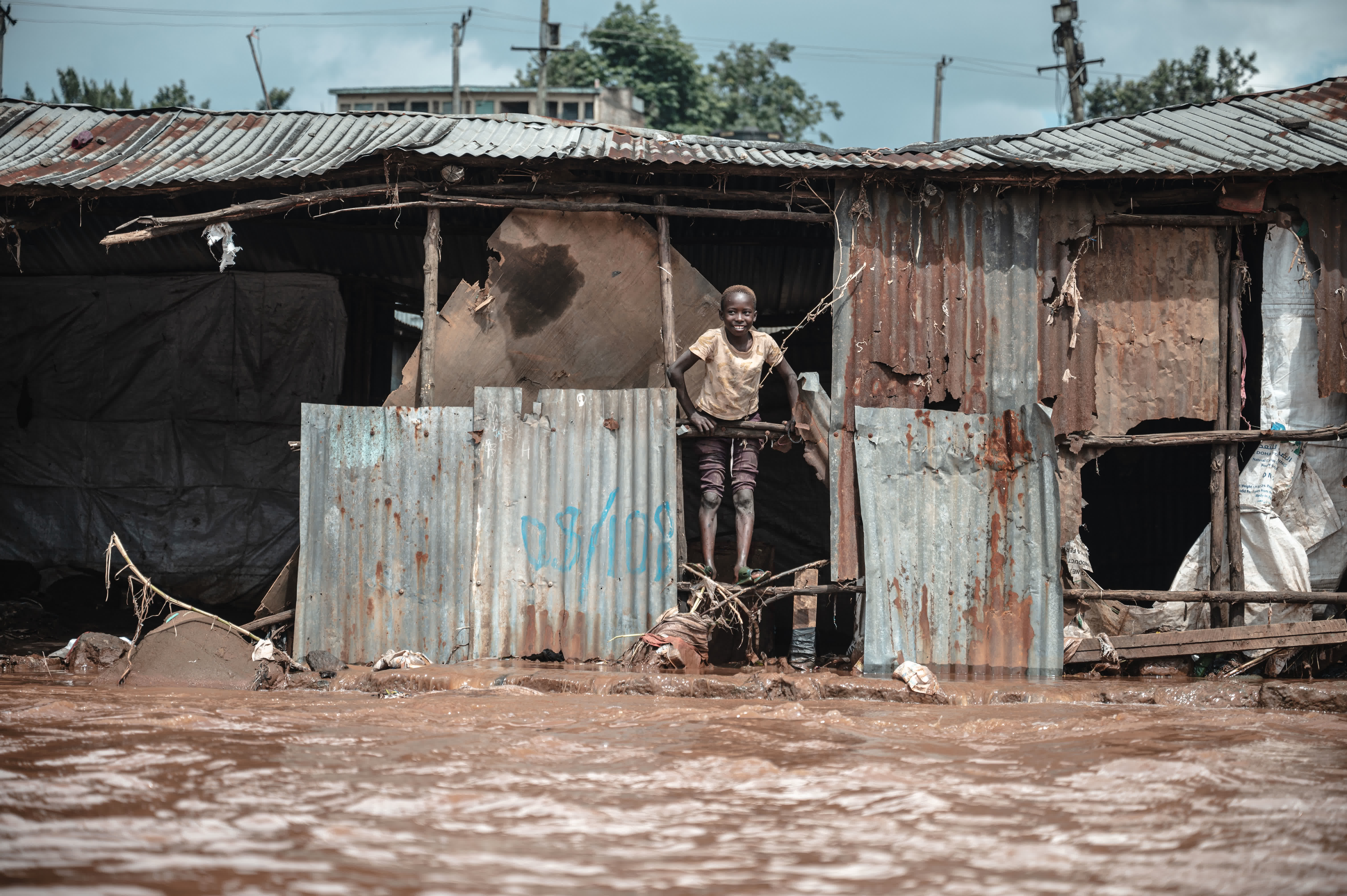 4月30日，在肯尼亞首都內羅畢的馬薩雷貧民區，一名兒童站在被洪水沖毀的房屋內。（新華社）