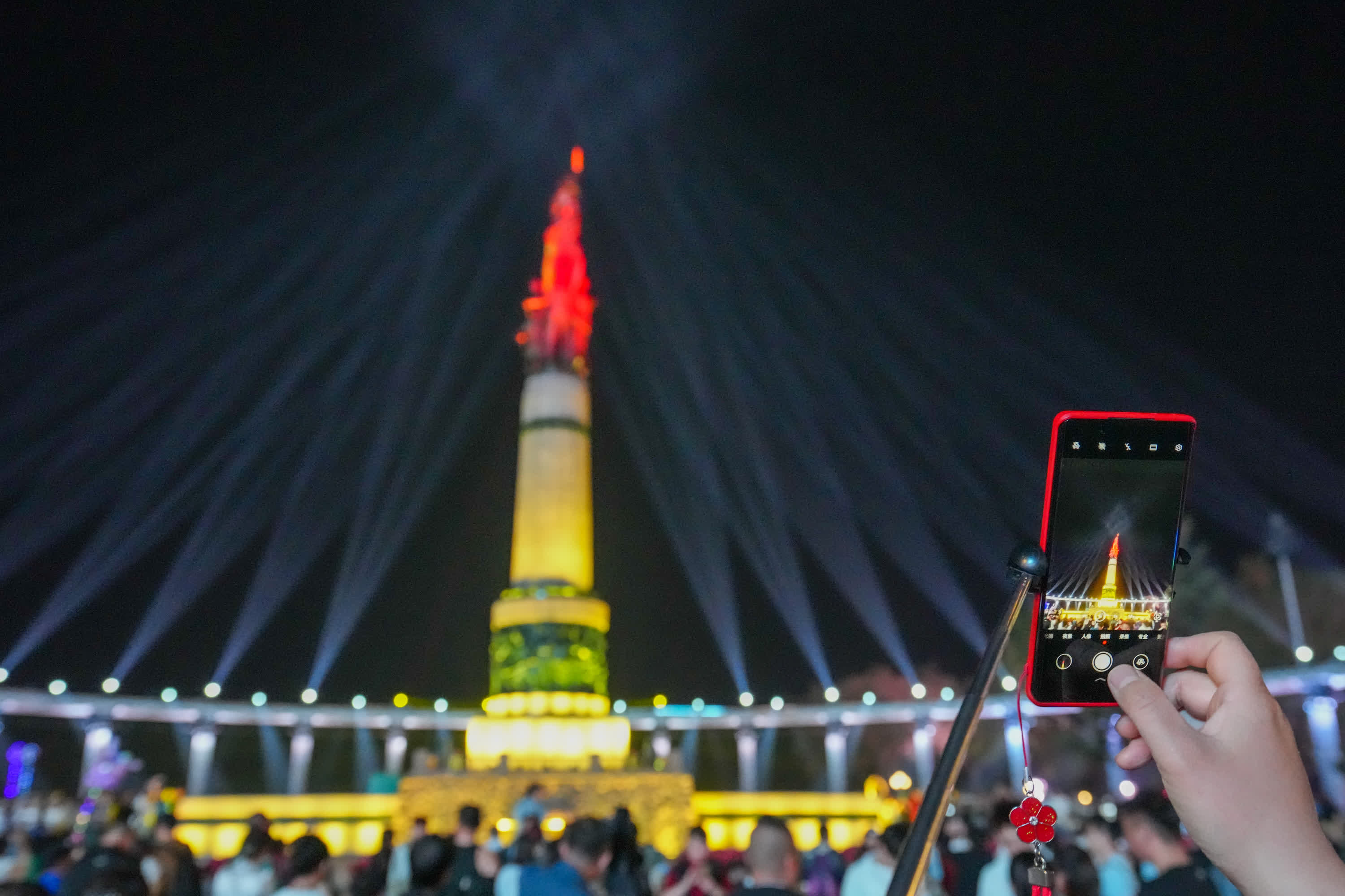 5月3日，遊客在哈爾濱防洪紀念塔廣場拍攝光影秀。（新華社）