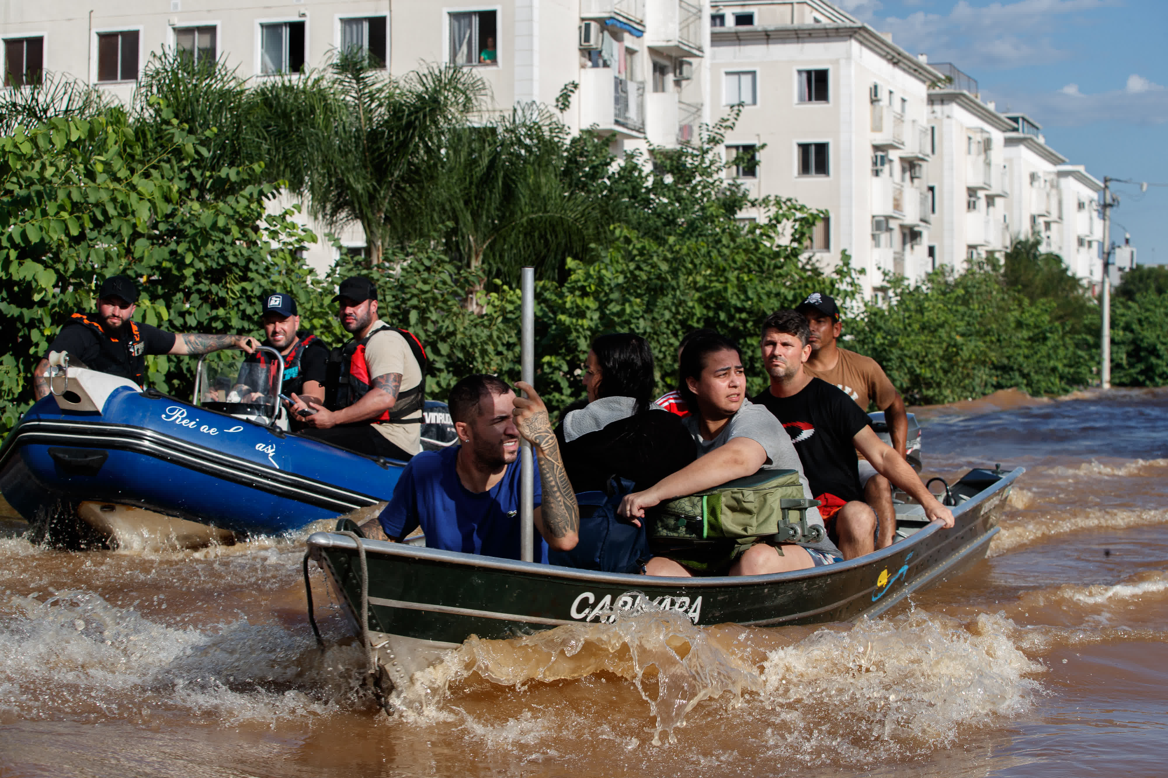 5月5日，在巴西南里奧格蘭德州聖萊奧波爾多，救援人員幫助當地居民轉移。（新華社）