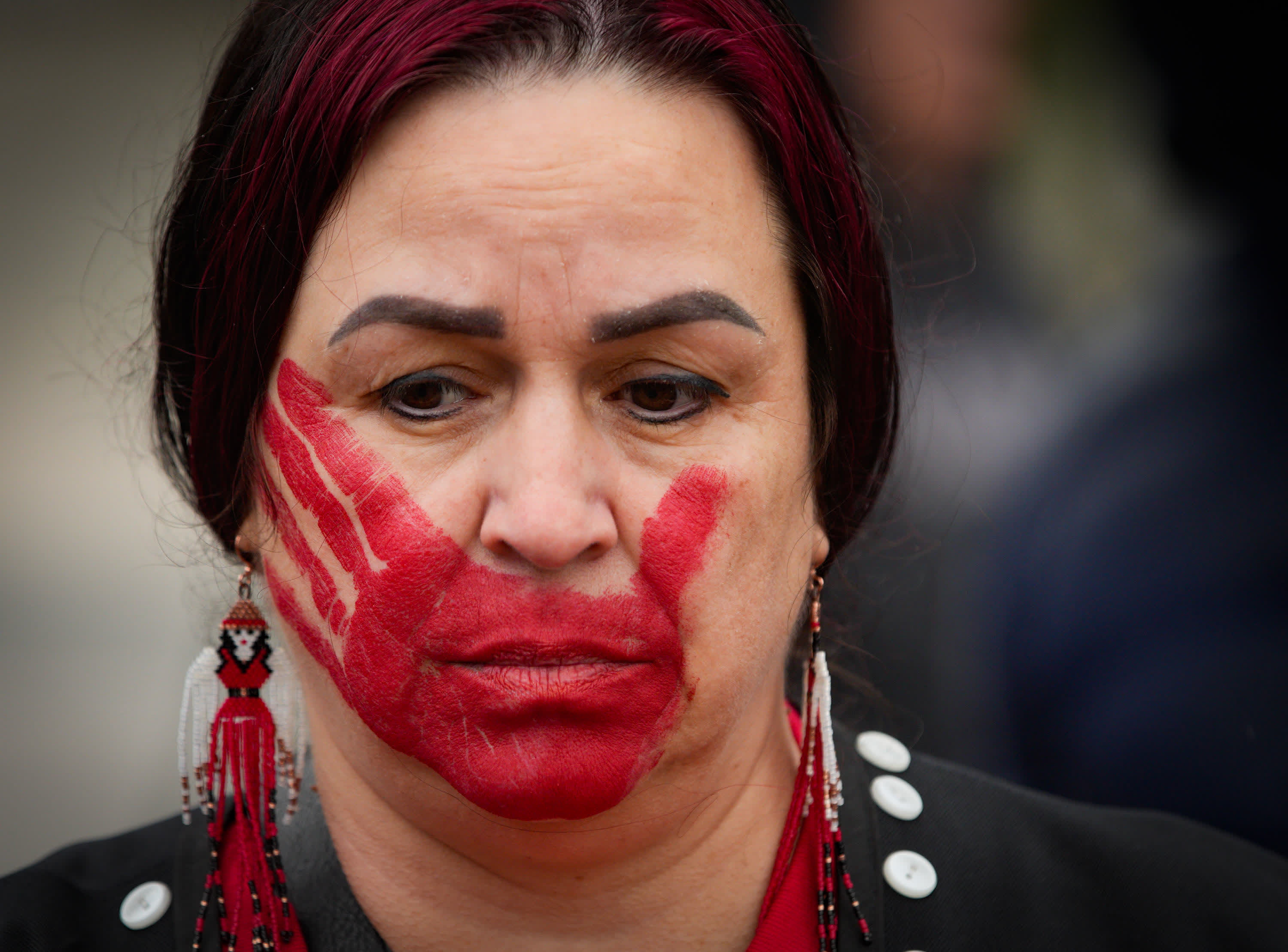 5月5日，在加拿大新威斯敏斯特舉辦的「紅裙日」紀念活動中，一名女子在臉上畫上紅色手印，紀念失蹤和被謀殺的原住民女性。（新華社）