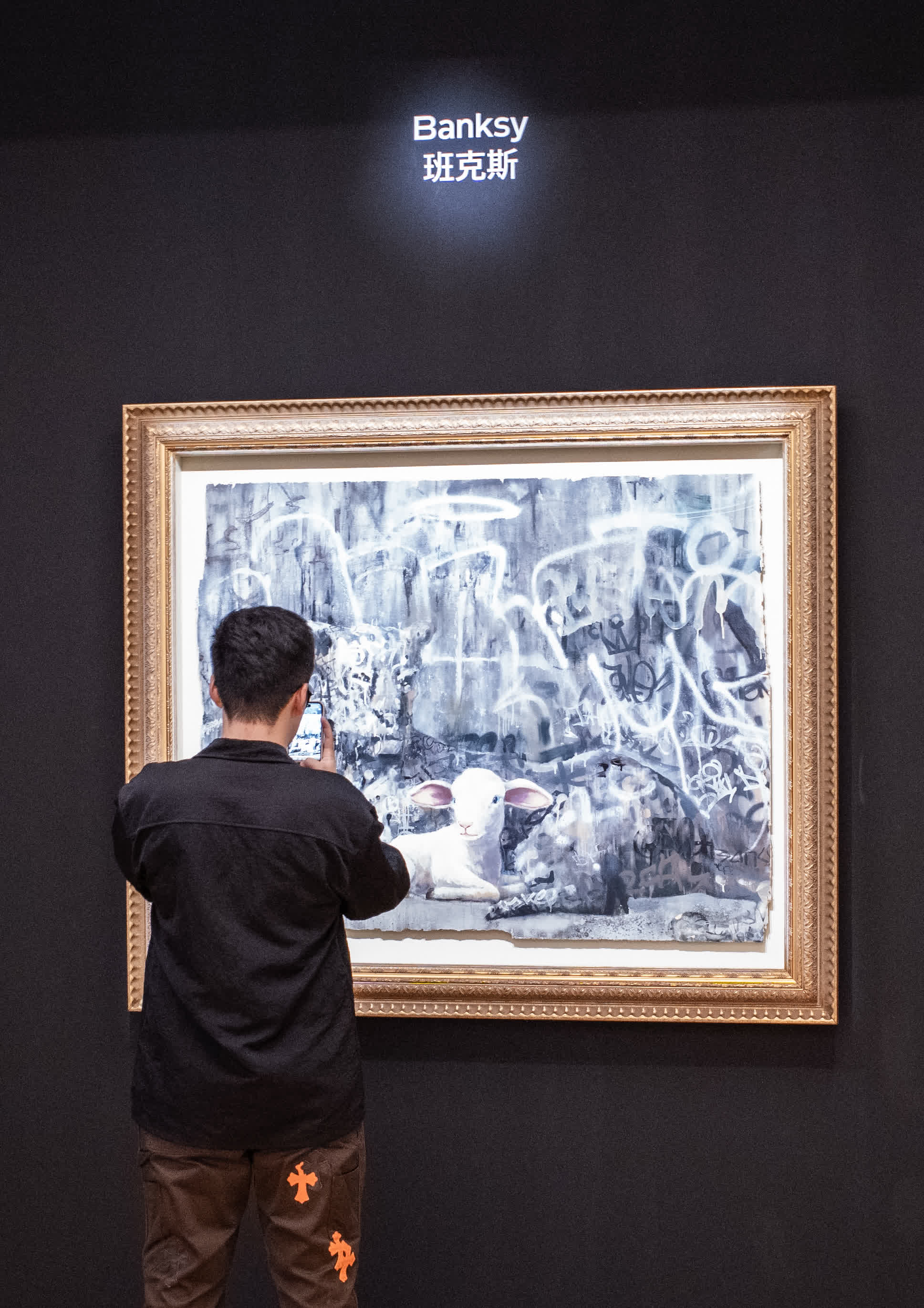 英國匿名塗鴉藝術家班克斯的作品《獵豹與羊》吸引觀眾參觀，該拍品估價約1800萬至2800萬港元。  （中新社）