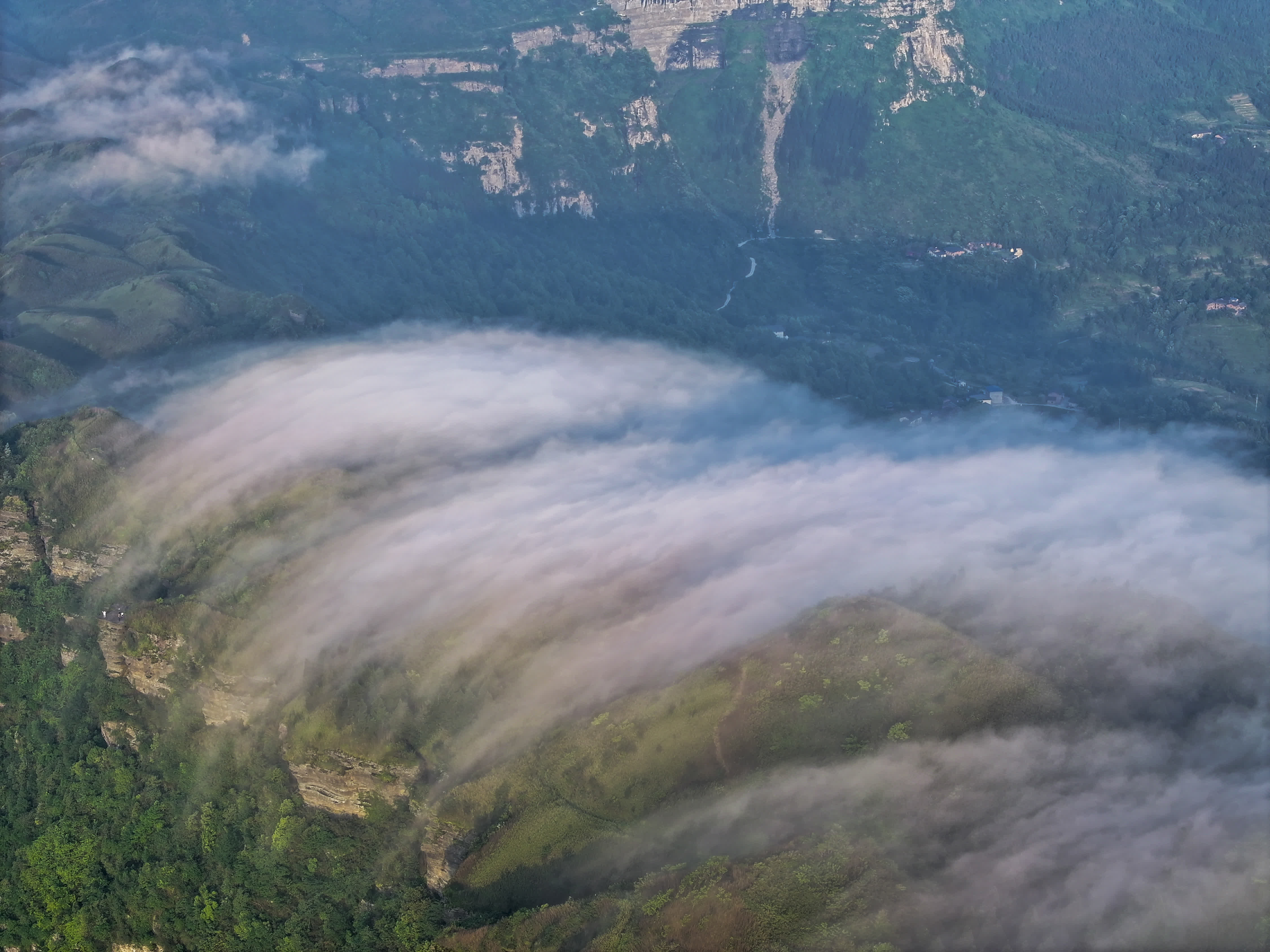5月23日，在重慶市南川區金佛山東麓，蒸騰的雲霧宛如瀑布順著山勢飛流而下（無人機照片）。（新華社）