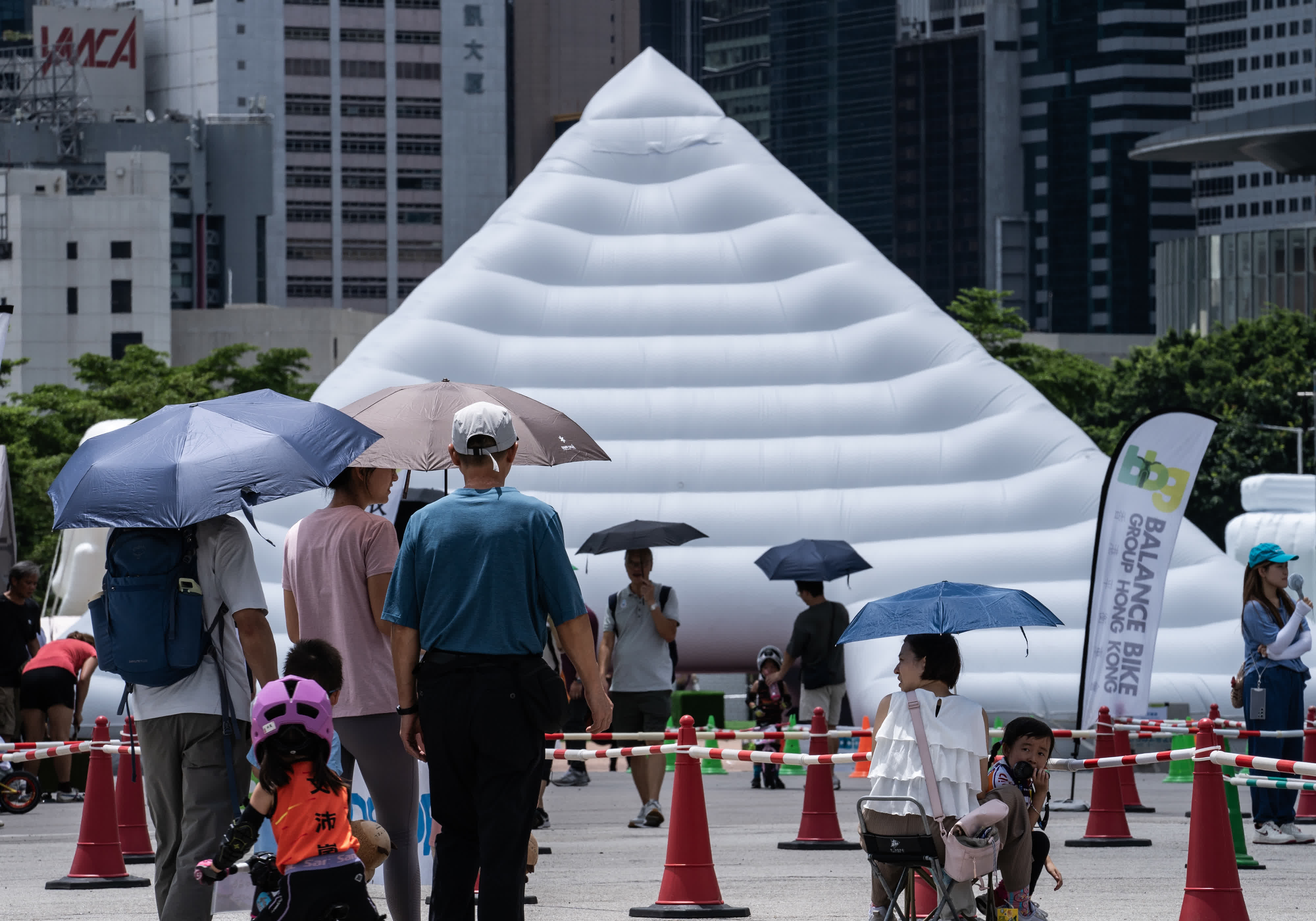 市民遊客經過香港中環海濱活動空間布置的「埃及金字塔」充氣裝置布景。  （中新社）