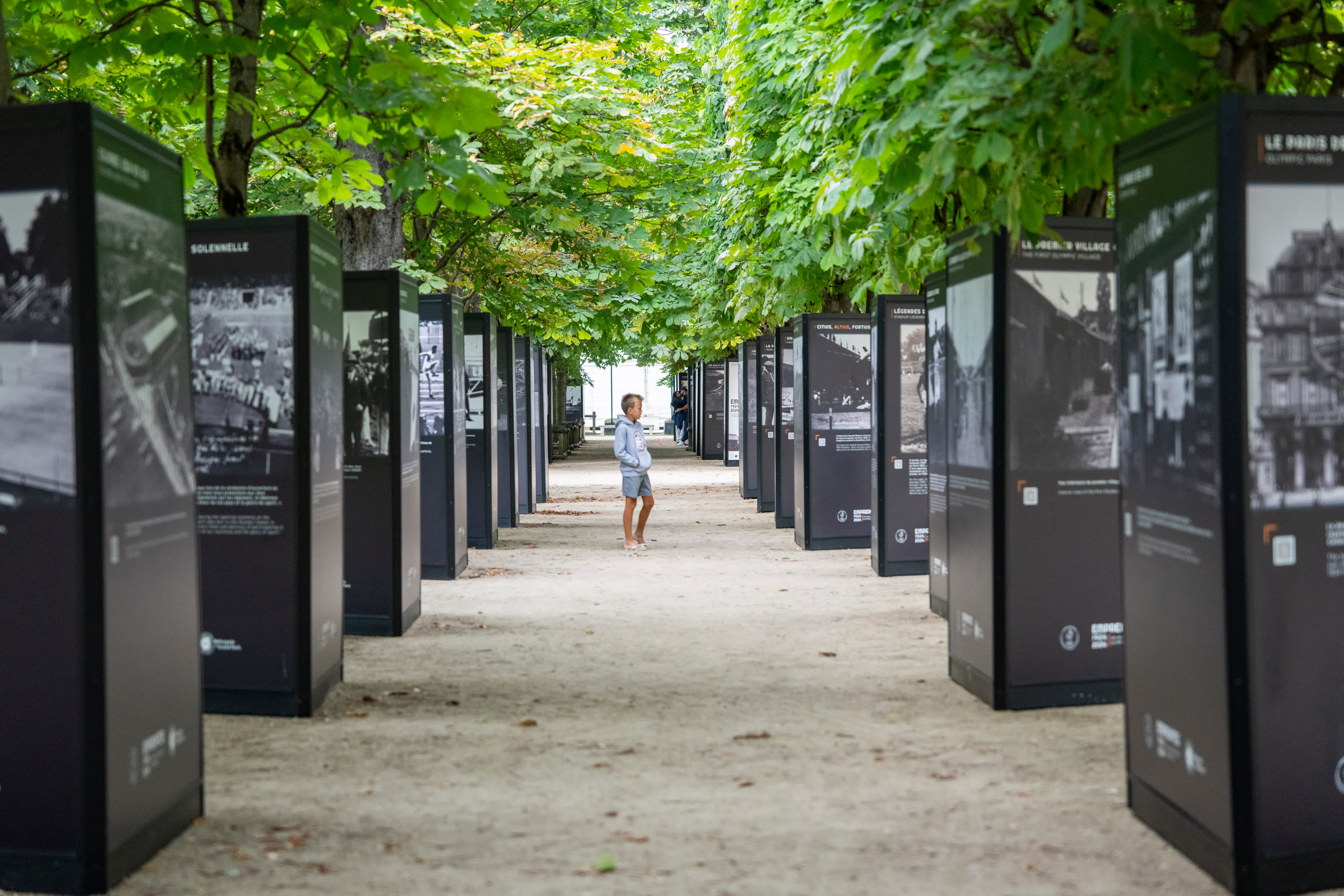 7月3日，一名參觀者觀看杜樂麗花園展出的1924年巴黎奧運會照片。（新華社）