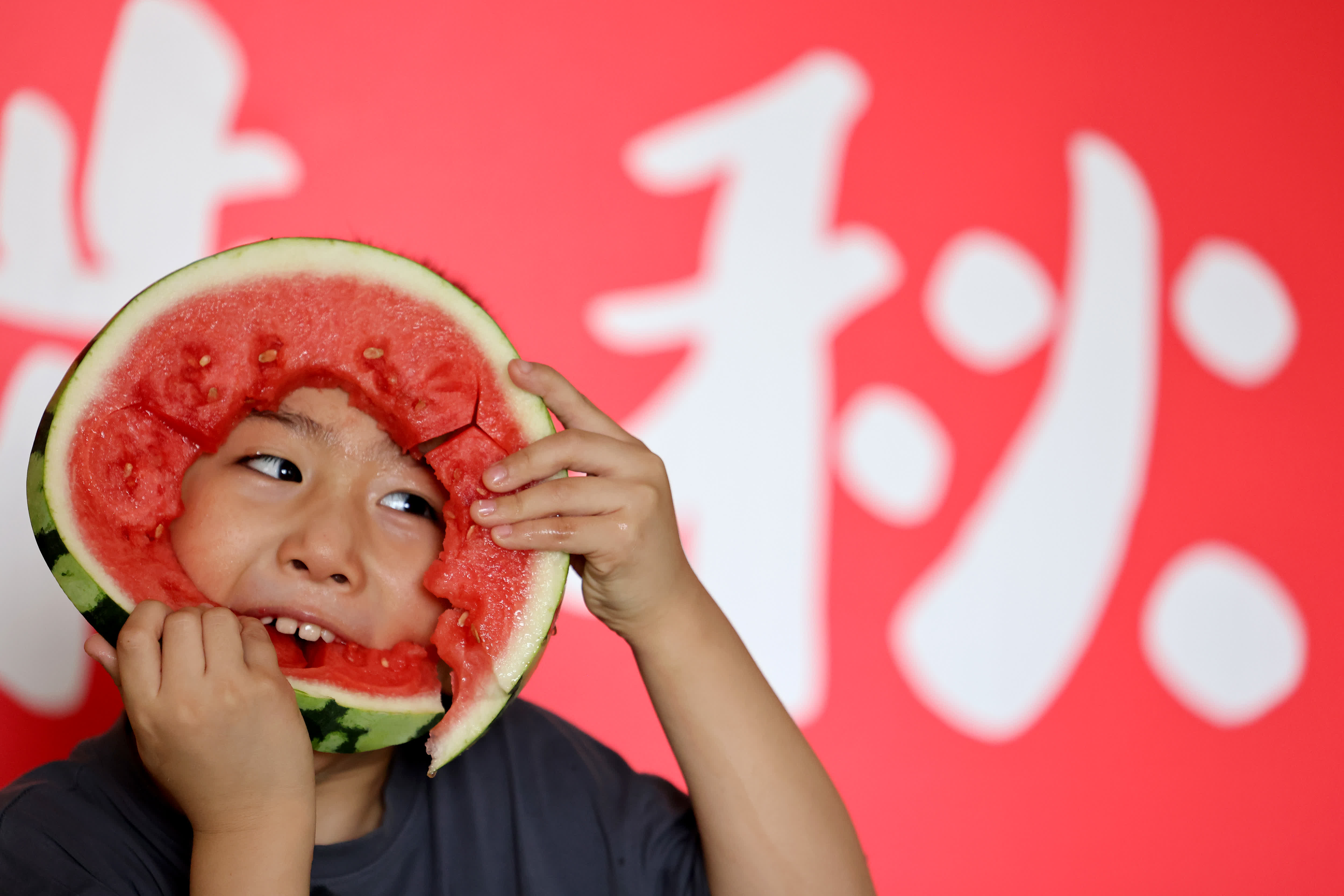 8月7日，在山東省棗莊市礦區街道北山社區暑期託管班，小朋友在「啃秋」吃西瓜。（新華社）