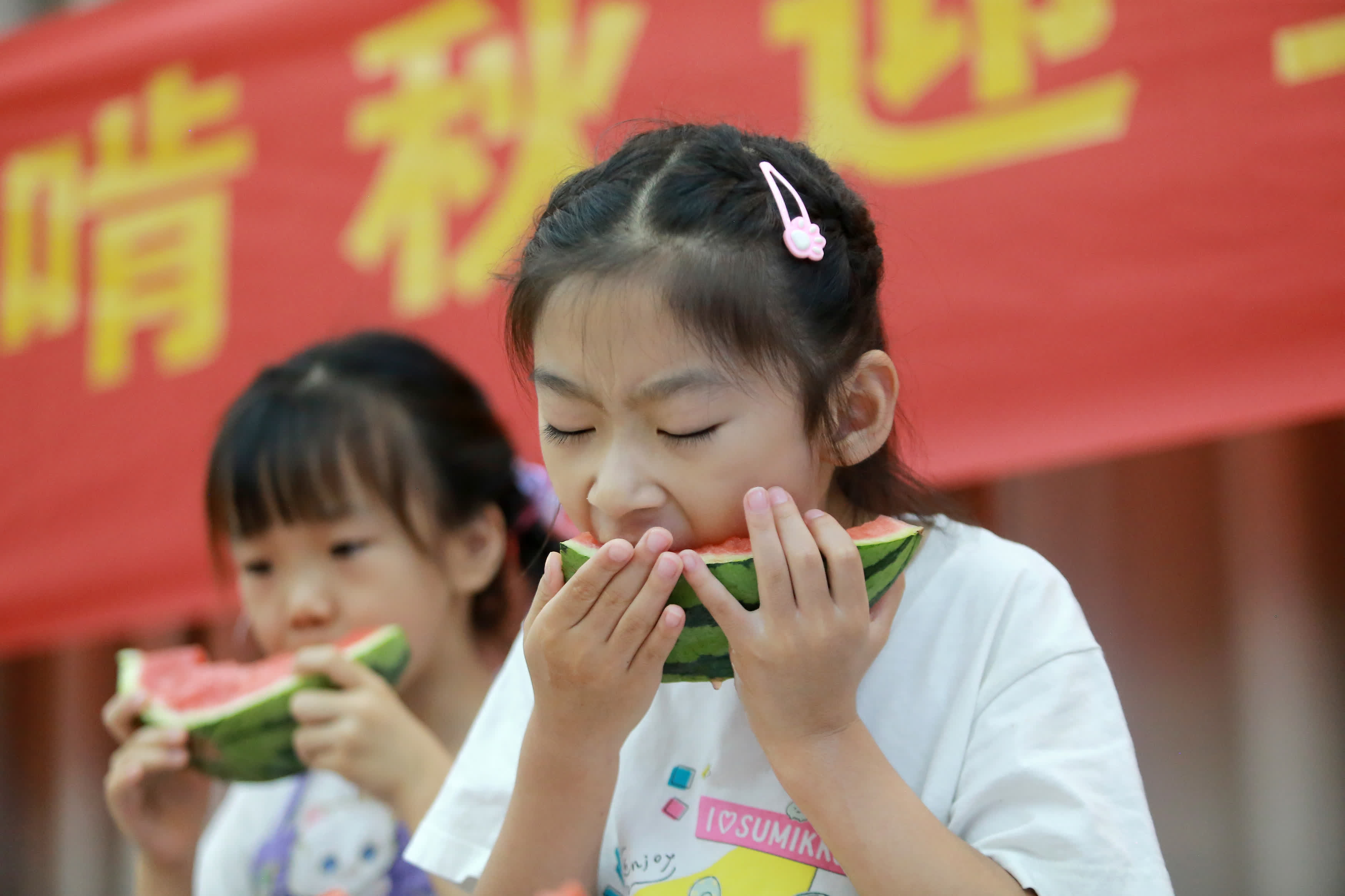 8月7日，在江蘇省揚州市邗上社區，小朋友們在「啃秋」吃西瓜。（新華社）