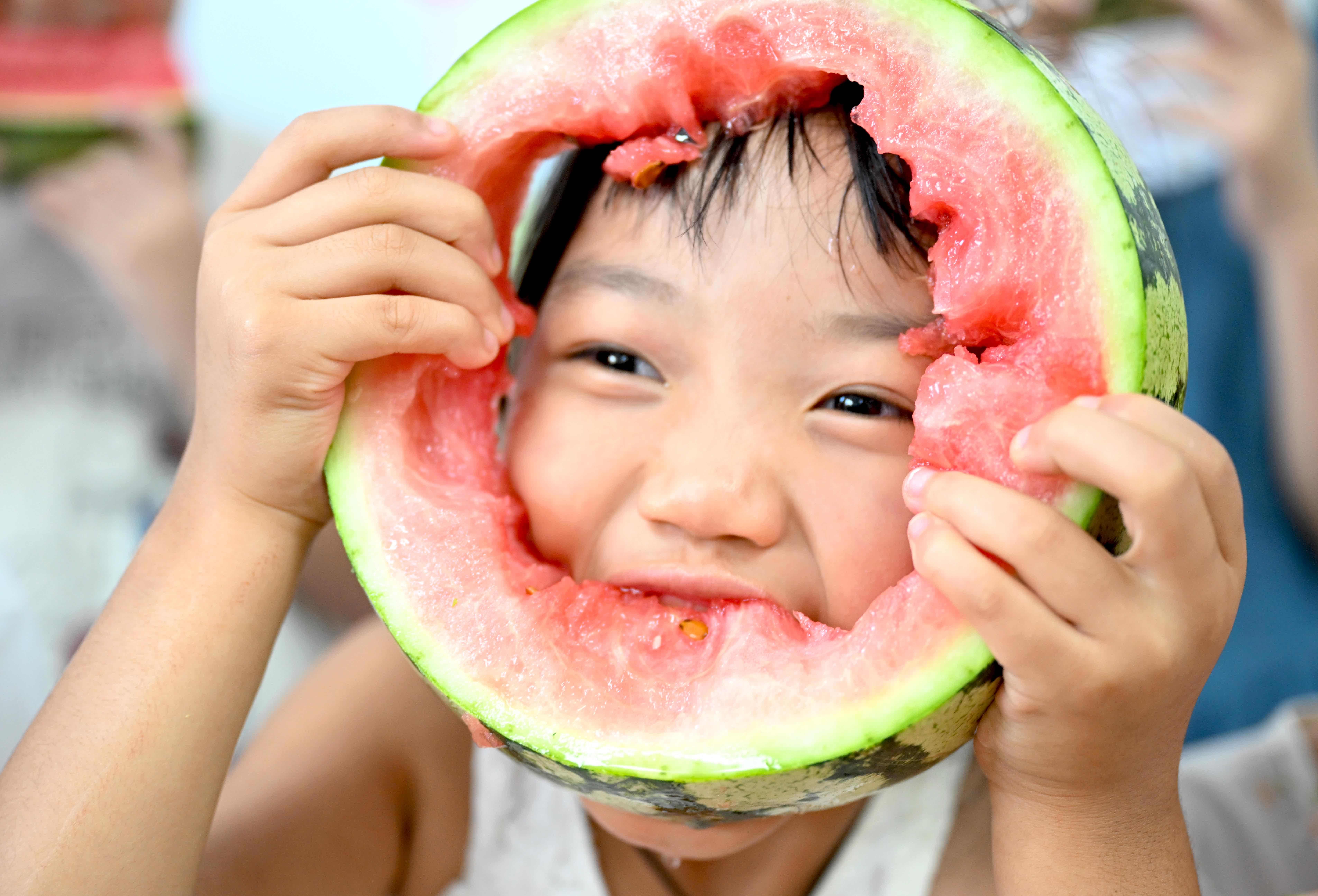 8月7日，在安徽省亳州市利辛縣永興鎮諸王社區青少年活動中心，小朋友在「啃秋」吃西瓜。（新華社）