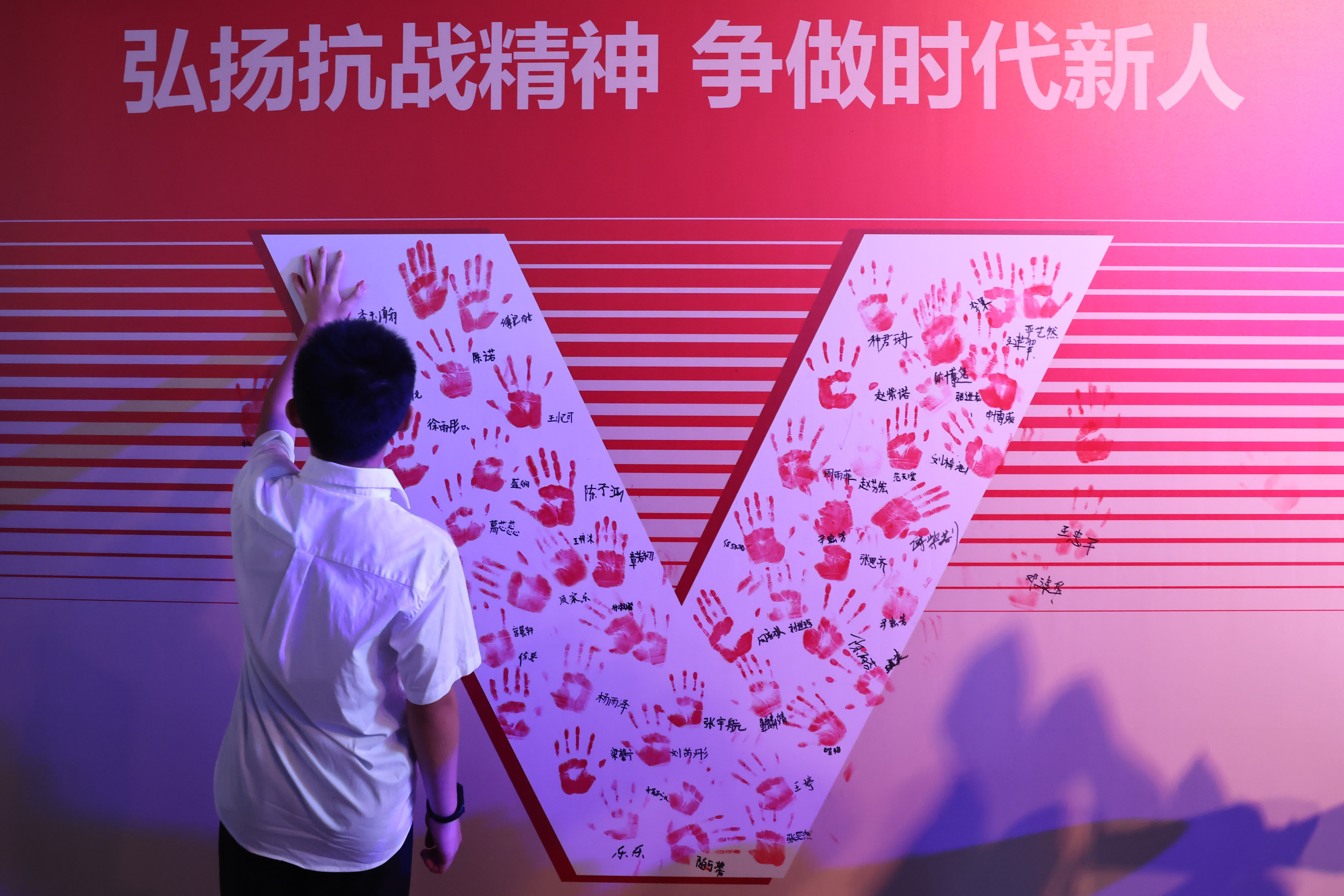 圖為青少年學生在象徵勝利的V字上留下手印。 （中新社）
  