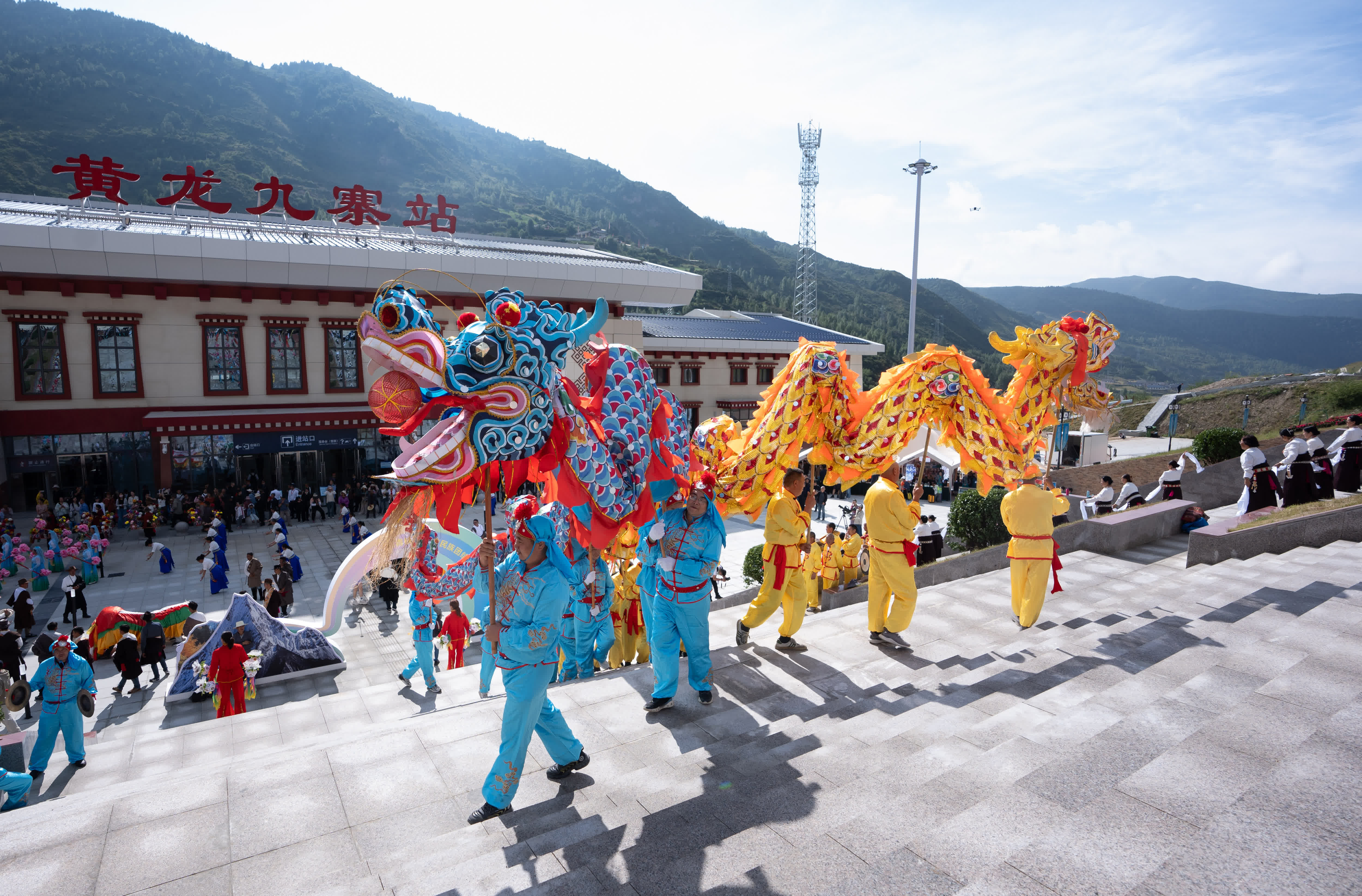 在黃龍九寨站，當地群眾在川青鐵路鎮江關至黃勝關段開通首發儀式上舞龍。（新華社）