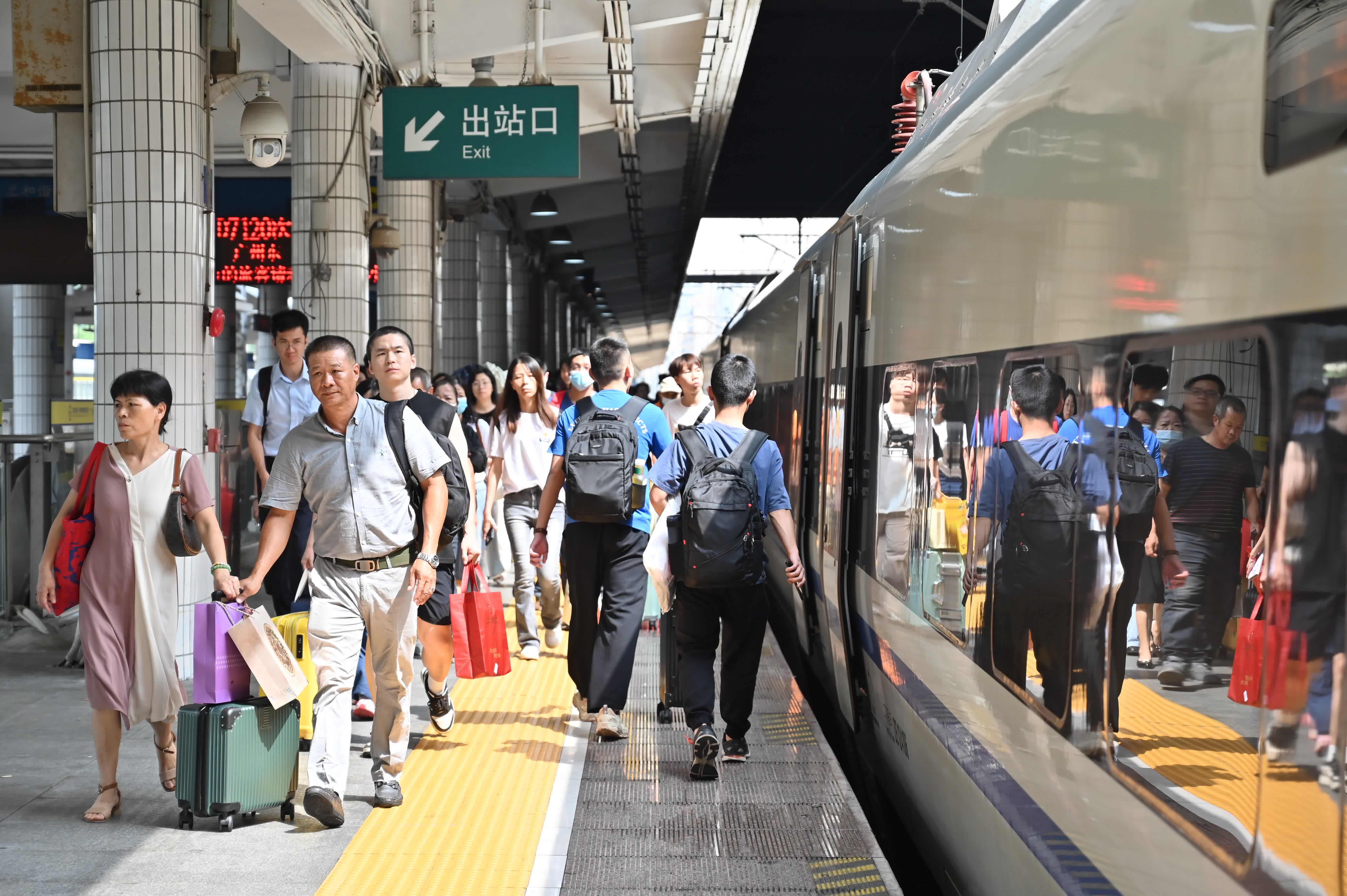 旅客在廣州東站搭乘動(dòng)車出行。