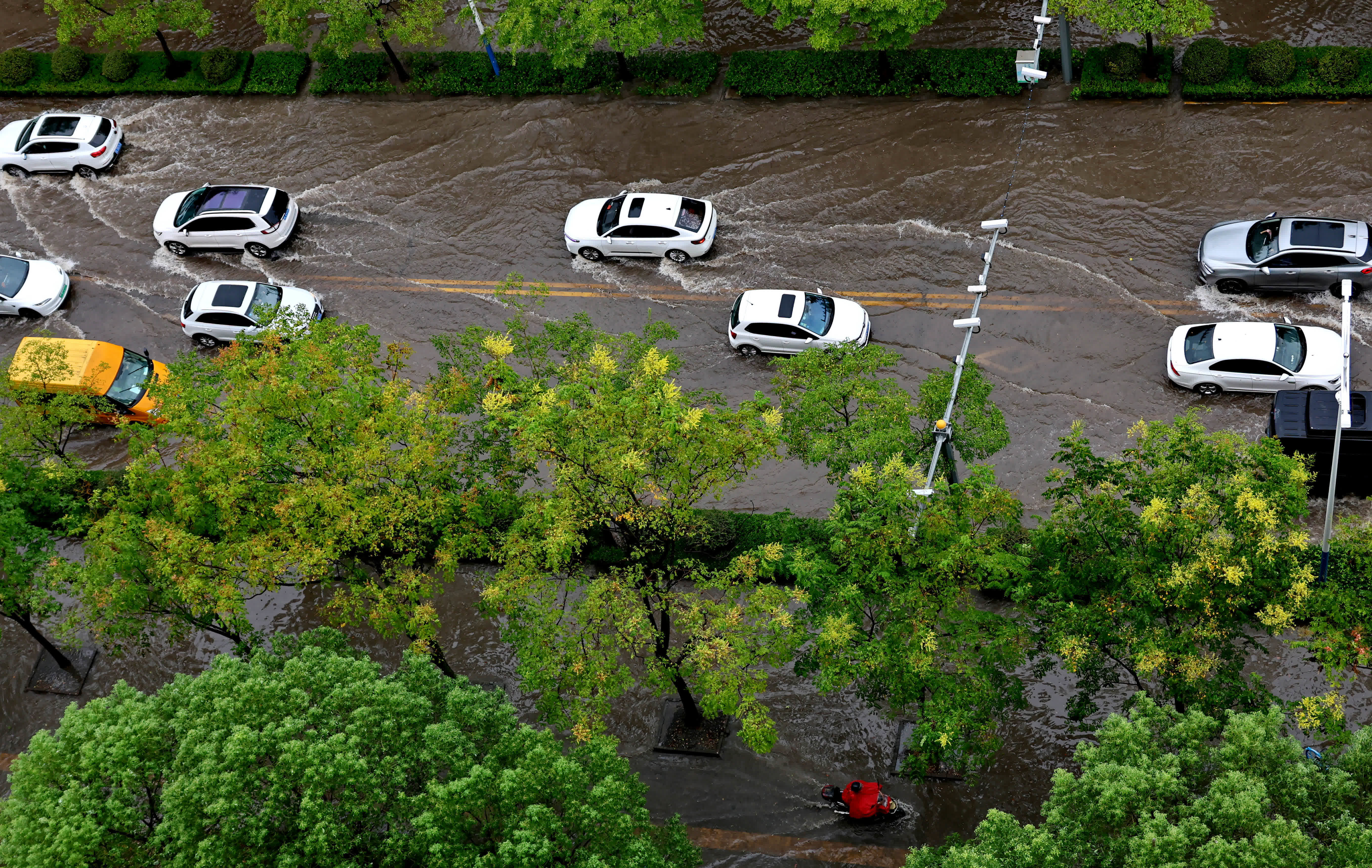 9月20日，在上海金山區(qū)龍皓路，車輛行駛在積水的道路上。（新華社）