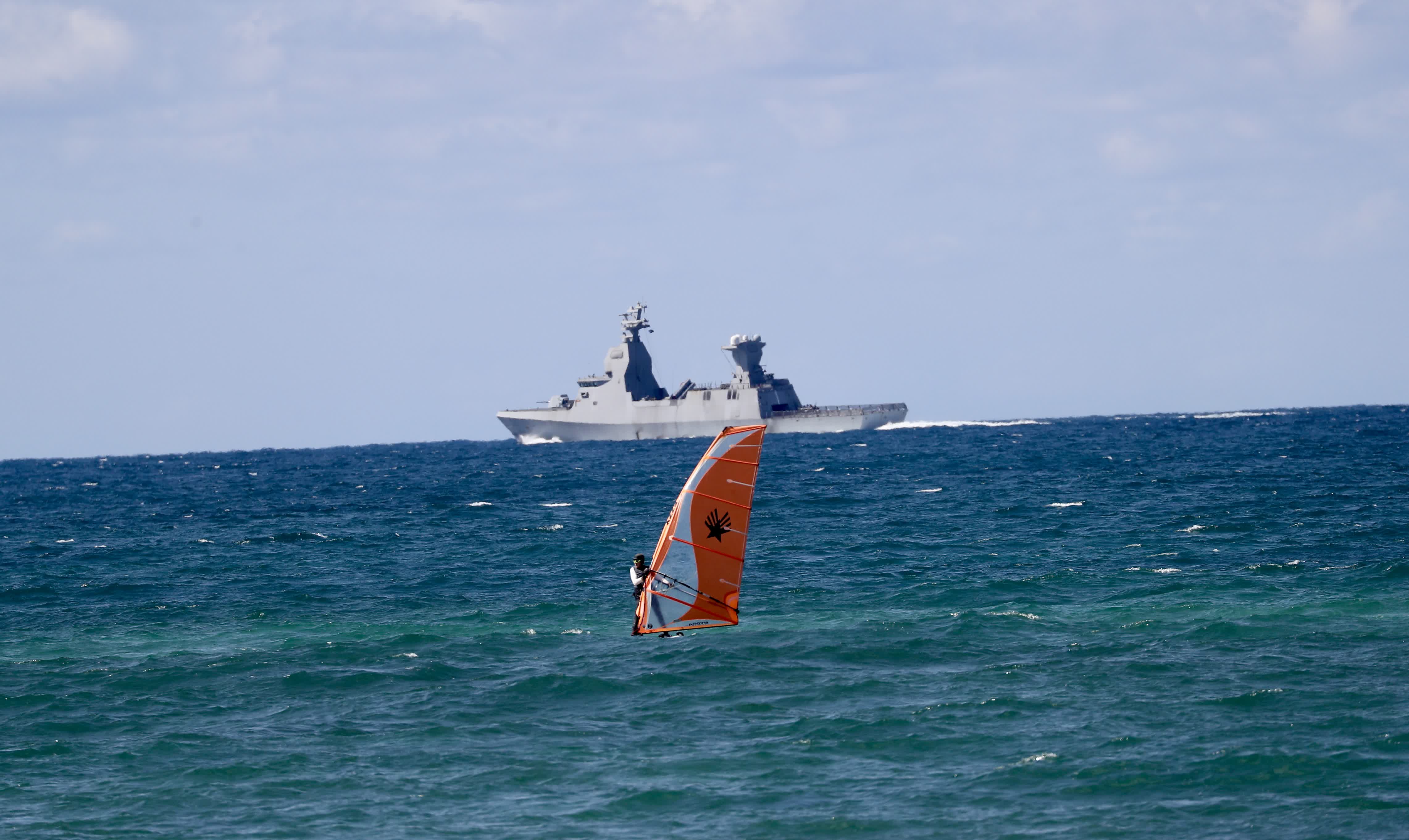 這是9月19日在以色列北部海法市拍攝的以軍軍艦和帆板愛(ài)好者。（新華社）