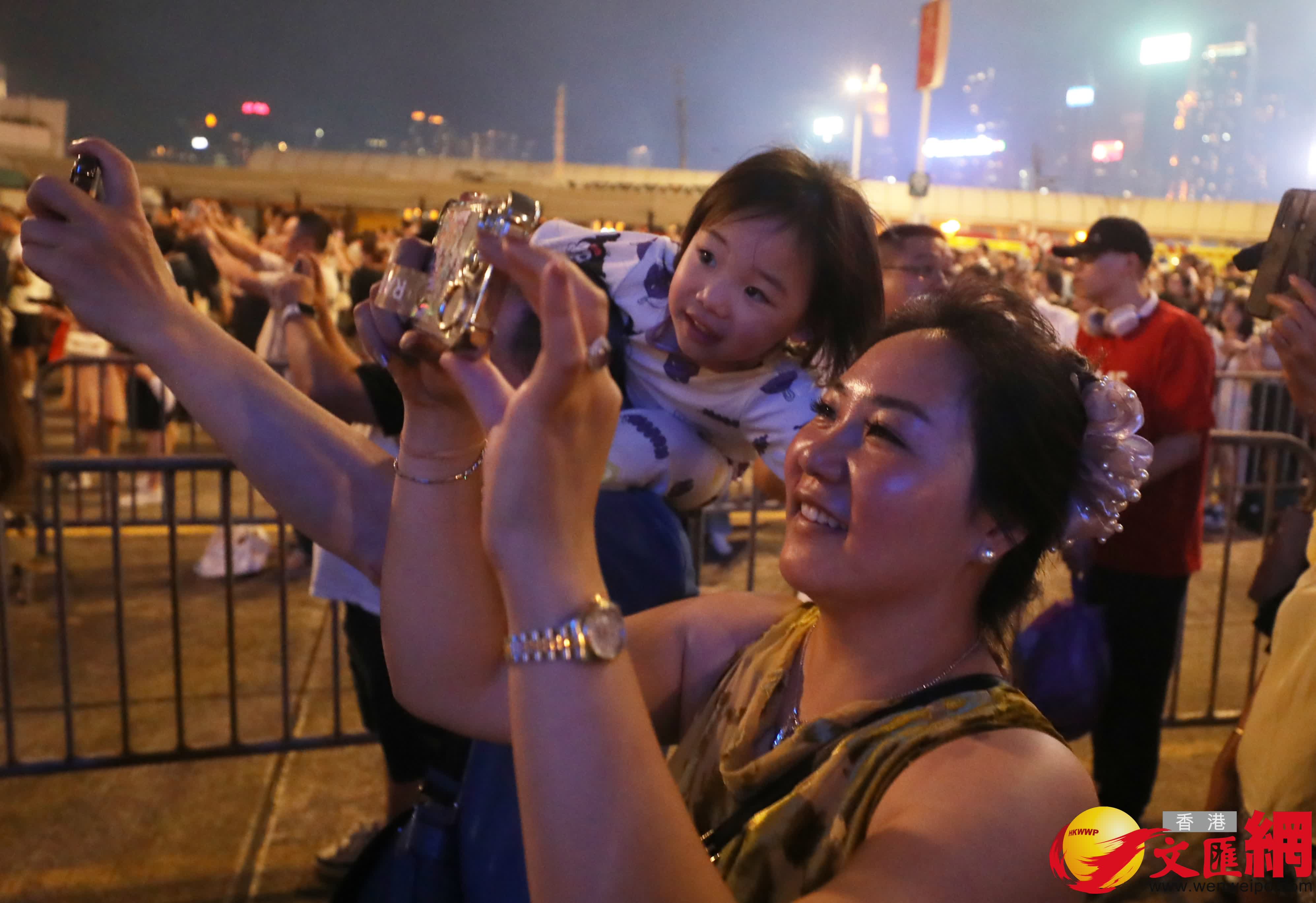 國慶煙花今晚9時在維港上演。圖為市民在拍攝煙花。（香港文匯報記者郭木又攝）