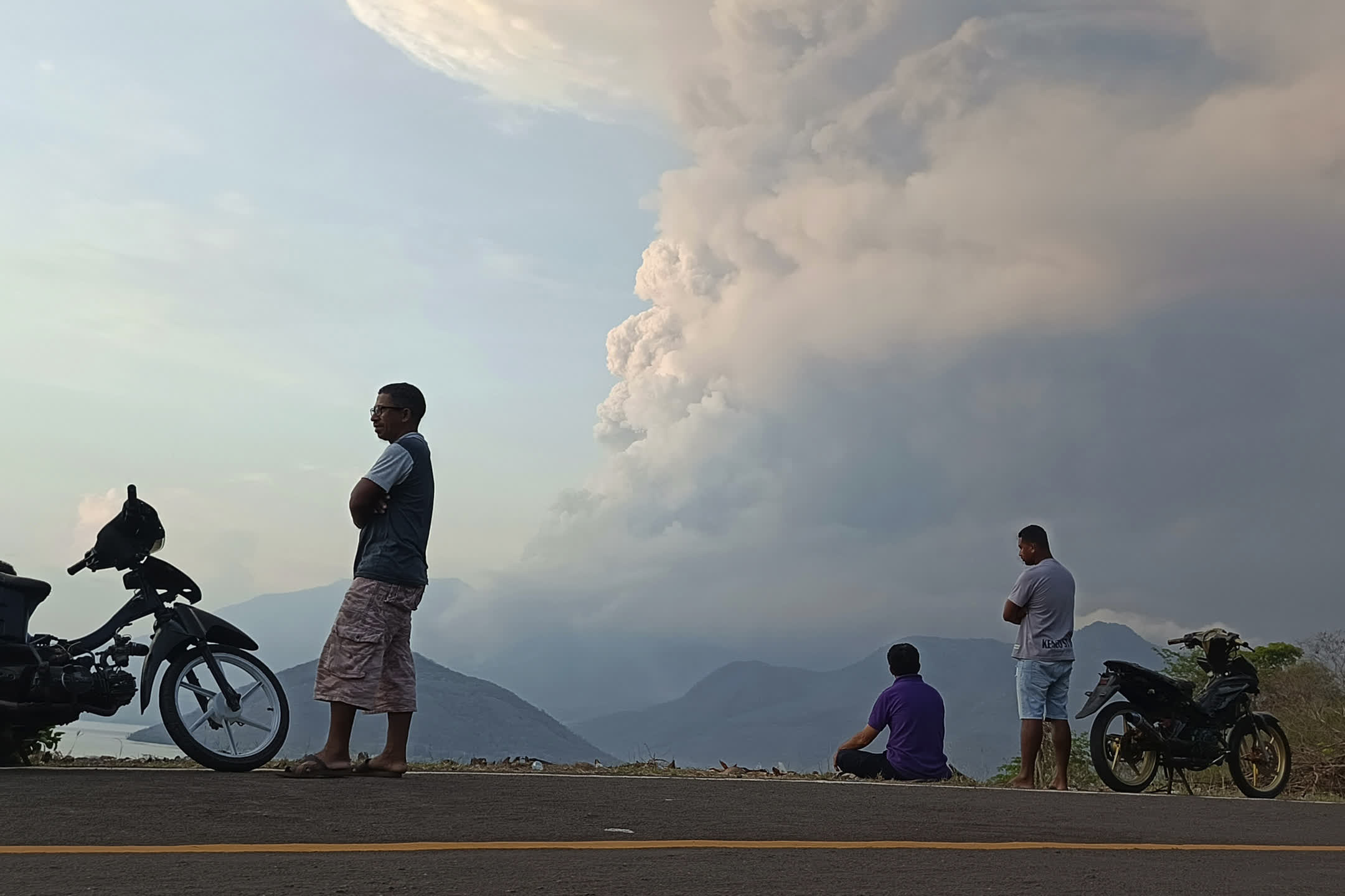 當?shù)貢r間11月9日8時50分，印尼勒沃托比火山發(fā)生噴發(fā)，火山灰柱達6000米，噴發(fā)持續(xù)時間約416秒。圖為居民觀看火山噴發(fā)時噴出的火山物質(zhì)。（美聯(lián)社）