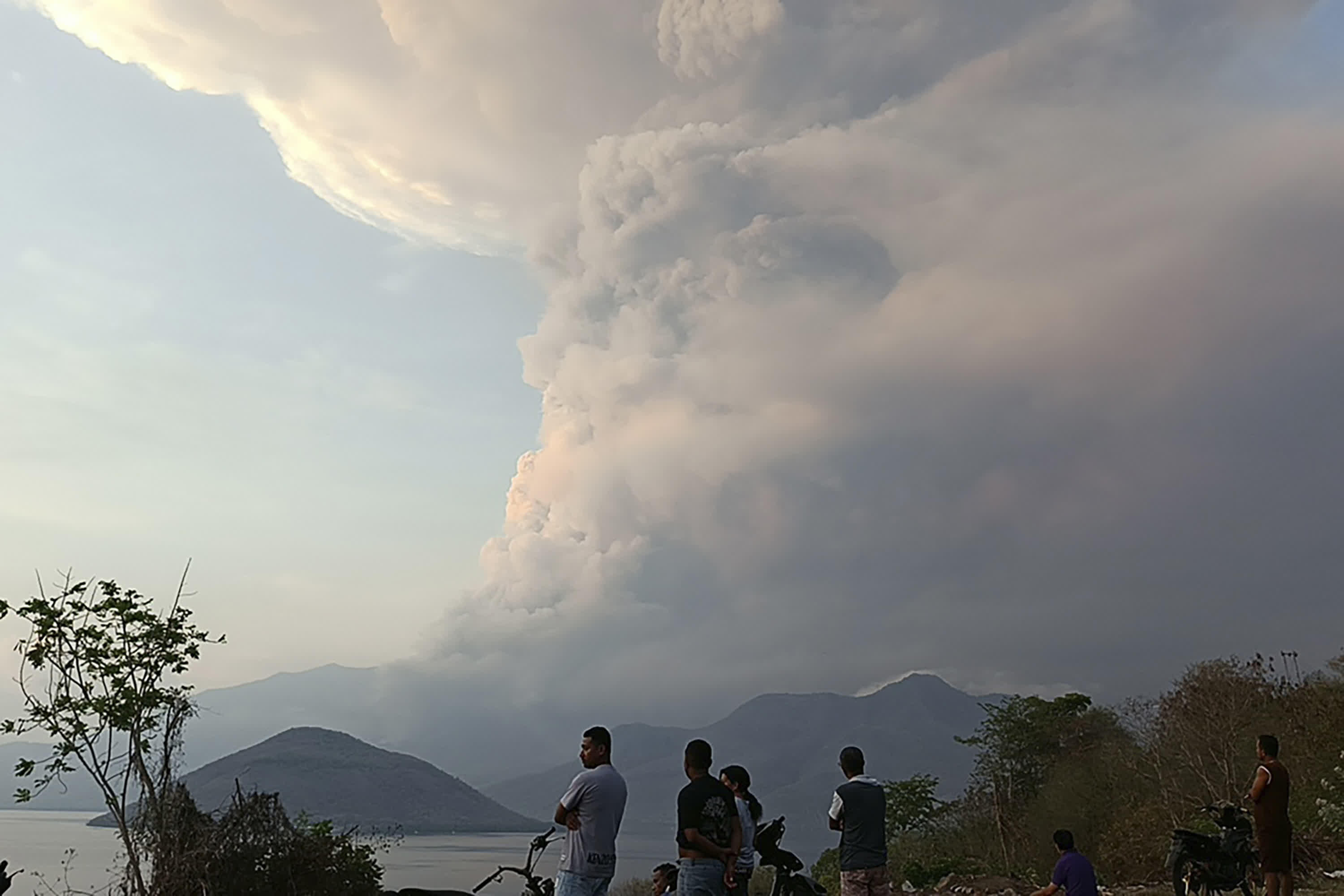 當?shù)貢r間11月9日8時50分，印尼勒沃托比火山發(fā)生噴發(fā)，火山灰柱達6000米，噴發(fā)持續(xù)時間約416秒。圖為居民觀看火山噴發(fā)時噴出的火山物質(zhì)。（美聯(lián)社）