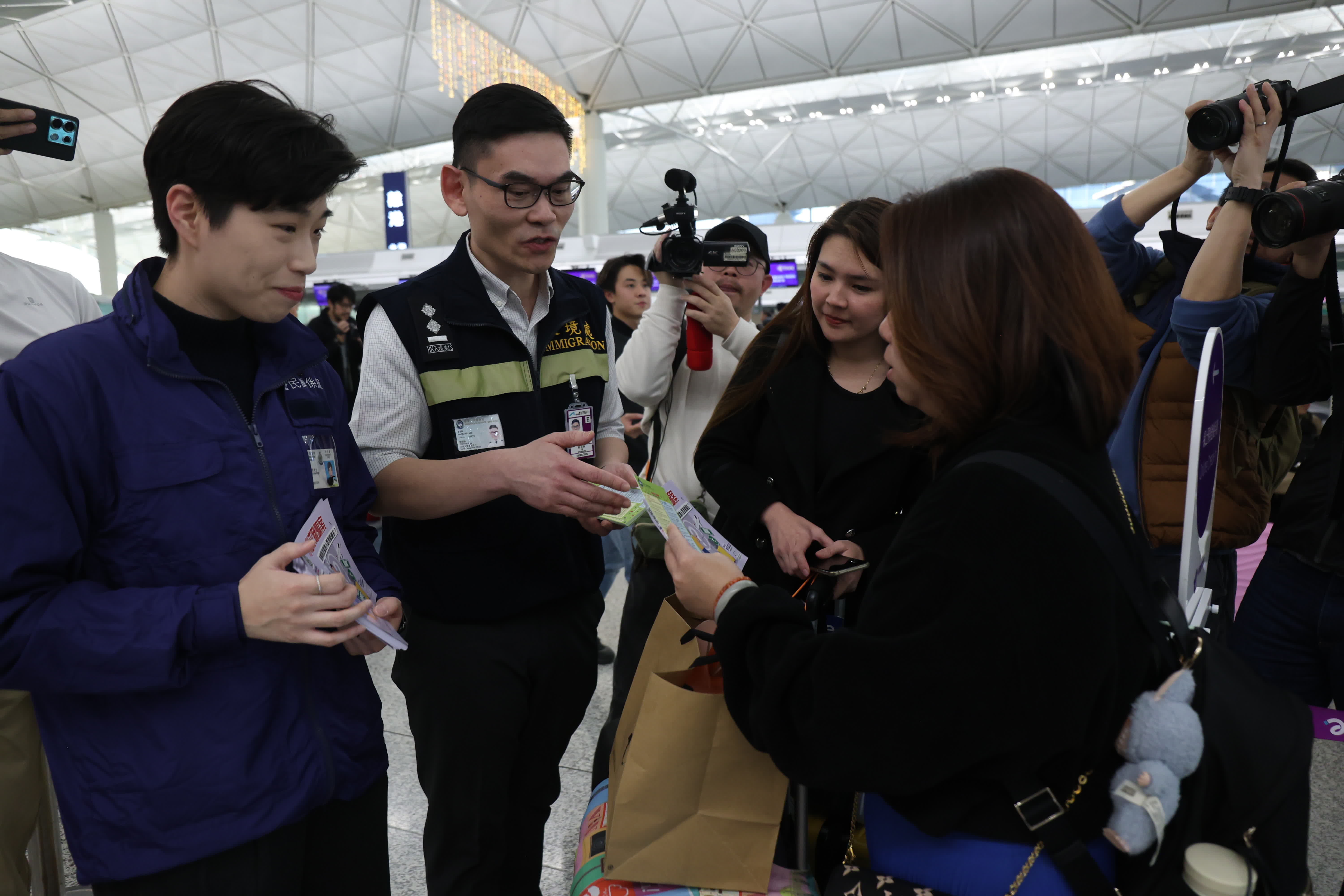 保安局專責(zé)小組於機場內(nèi)派發(fā)宣傳單張，警示前往泰國旅客小心被騙（香港文匯報記者萬霜靈 攝）