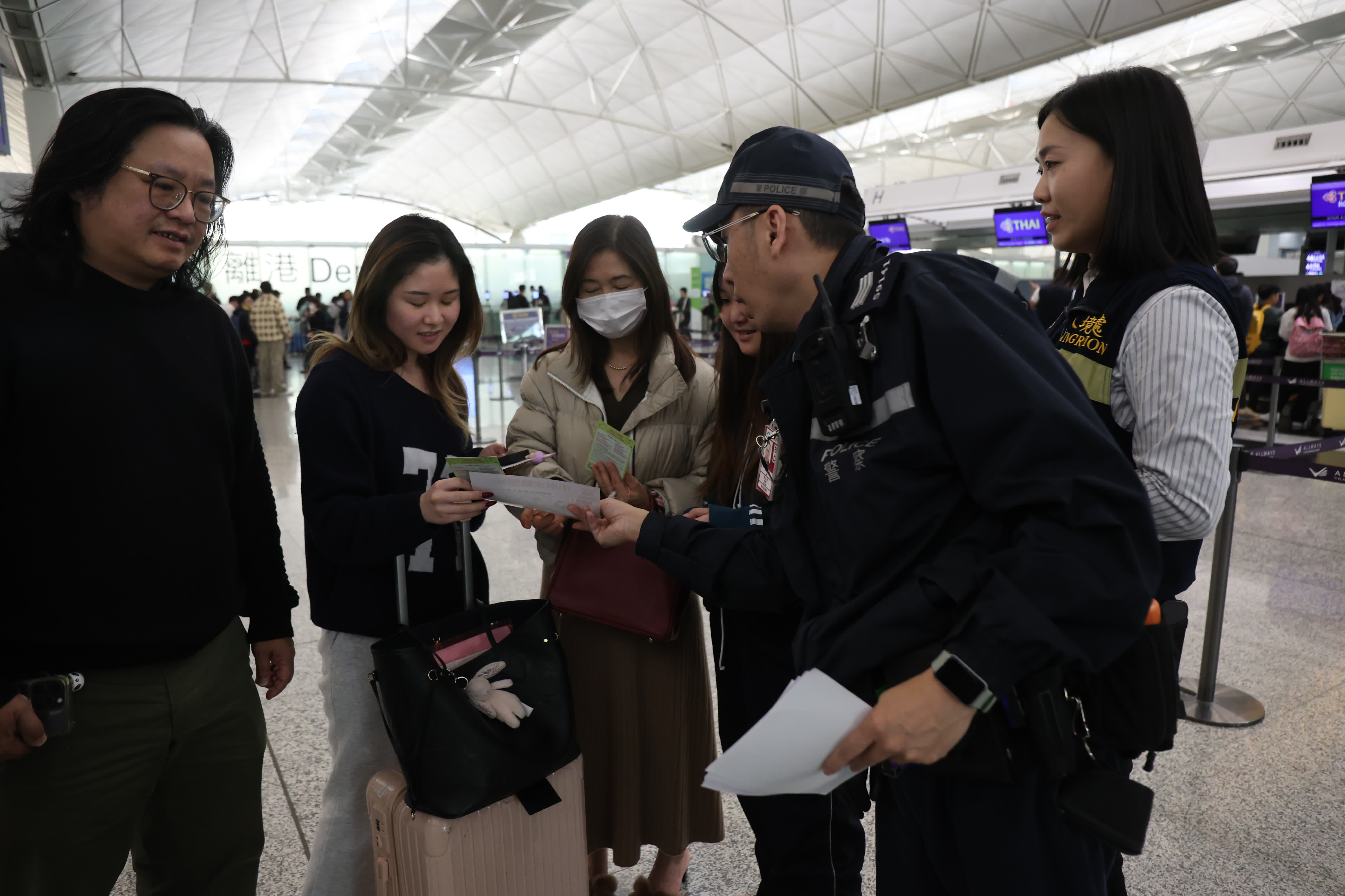 保安局專責(zé)小組於機場內(nèi)派發(fā)宣傳單張，警示前往泰國旅客小心被騙（香港文匯報記者萬霜靈 攝）