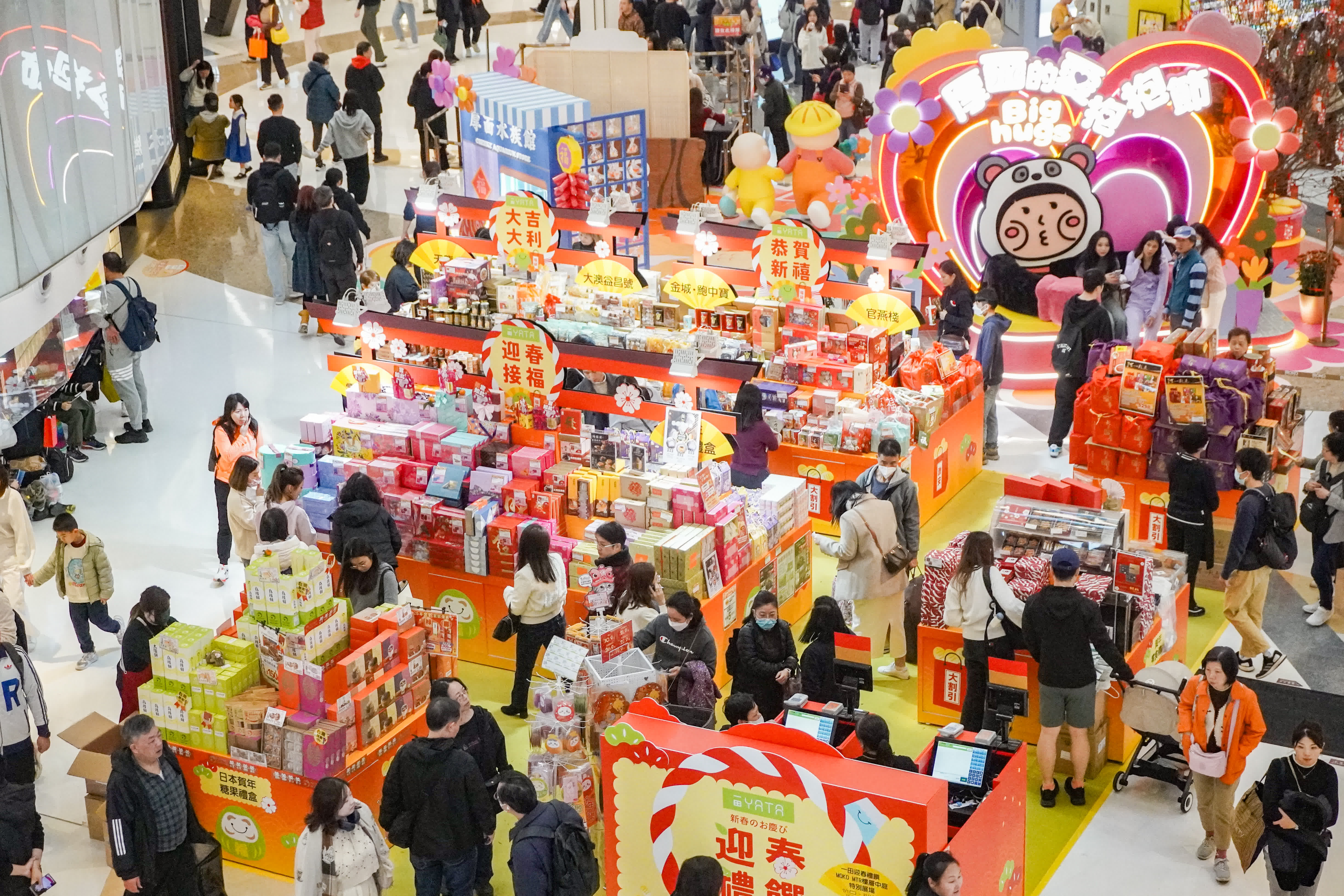 圖為旺角東一間商場，年貨鋪位火爆，人流眾多，商場亦派發揮春吸引市民。（香港中通社）